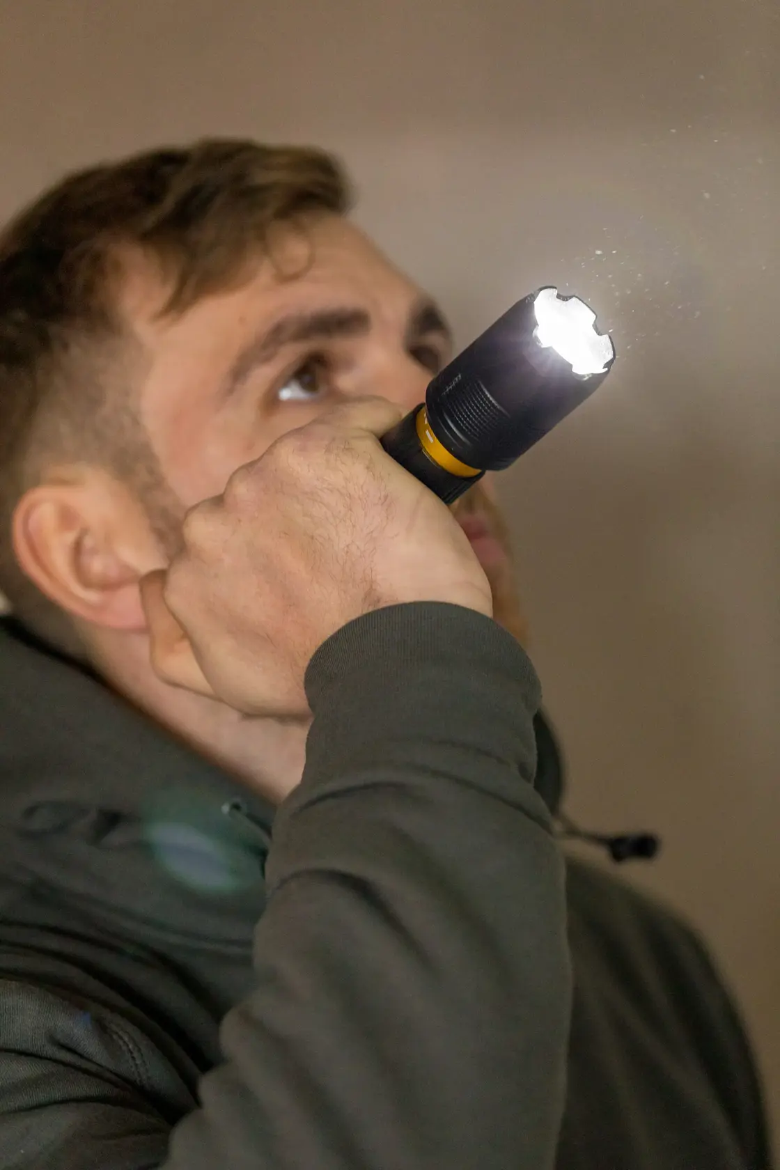 Foto der STANLEY FMHT81511-0 Taschenlampe, von Person gehalten, Lichtstrahl sichtbar im Innenbereich.
