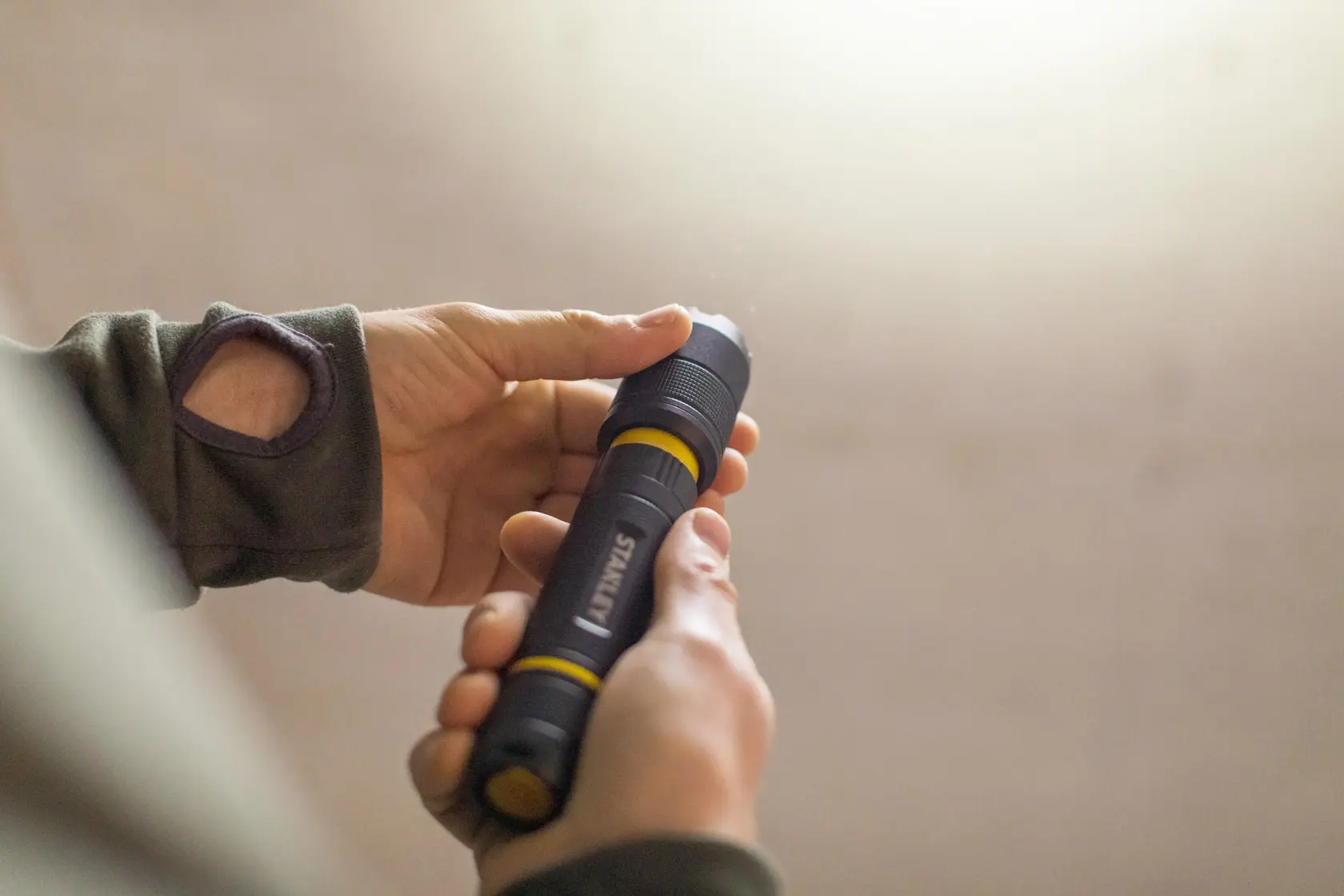 Foto der schwarzen und gelben STANLEY FMHT81511-0 Taschenlampe, die in der Hand gehalten wird.