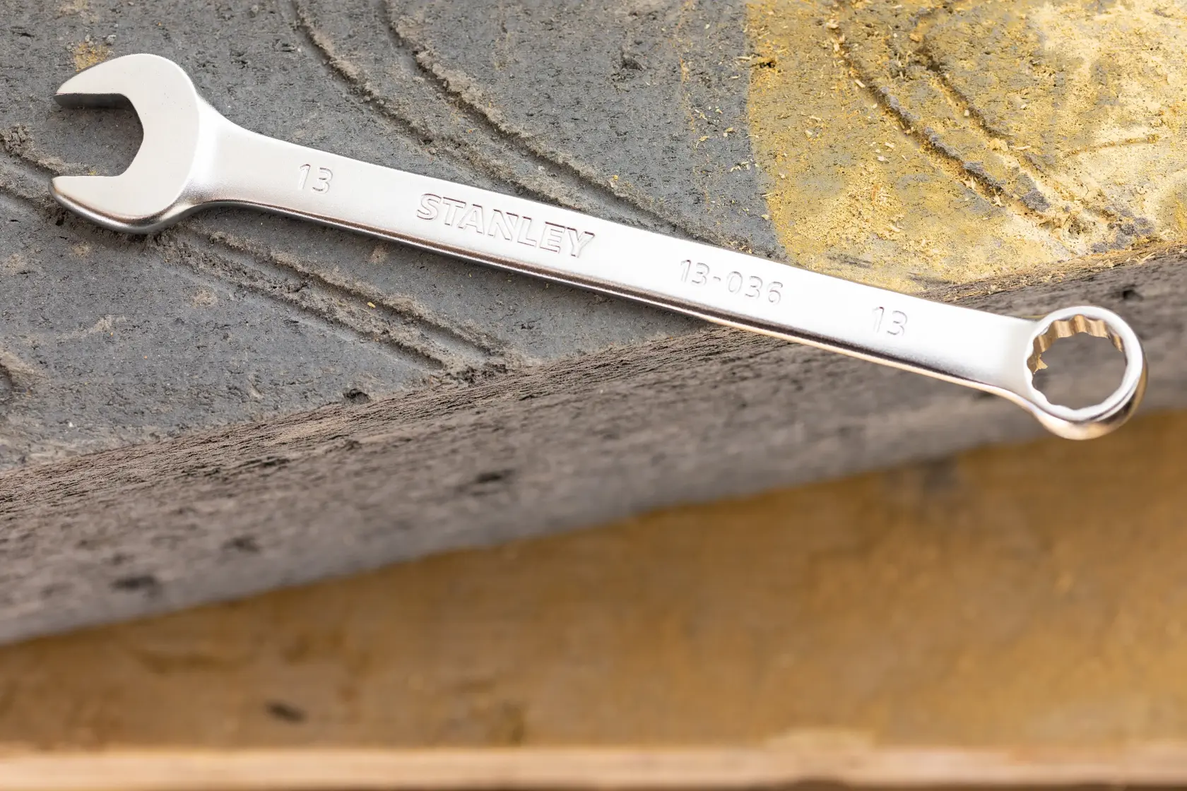STANLEY FMMT13042-0 Kombinationsschlüssel in Silber, auf strukturierter Betonoberfläche liegend.