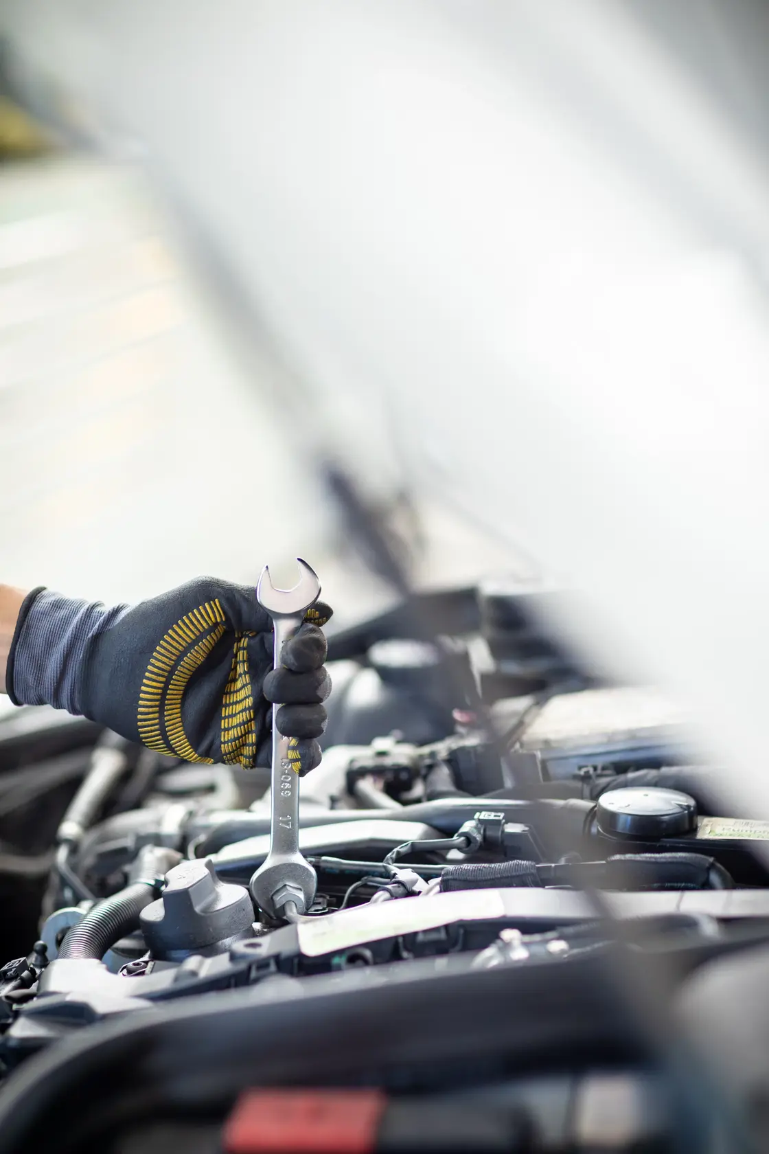 Stanley FMMT13066-0 Schraubenschlüssel bei Motorarbeit, Nahaufnahme mit Handschuh, Kategorie Fotografie.