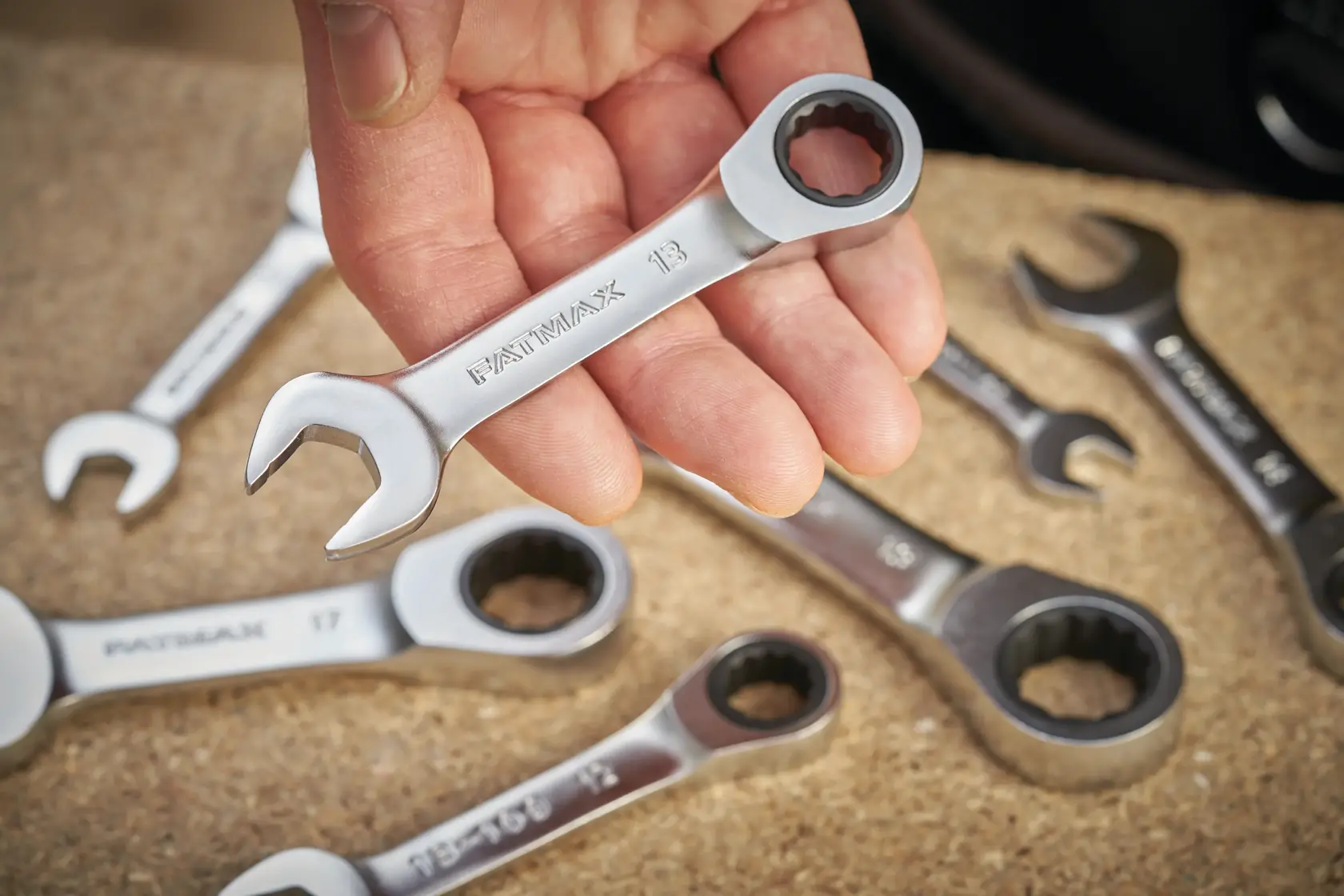 STANLEY FMMT13098-0 Ratschen-Ringmaulschlüssel-Set, Nahaufnahme mit Hand hält einen Schlüssel, weitere Schlüssel sichtbar.