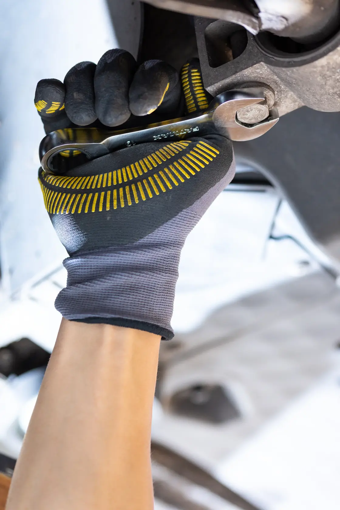 Fotografie von STANLEY FMMT13111-0 Mechaniker mit Schraubenschlüssel, schwarze und gelbe Handschuhe, Nahaufnahme.
