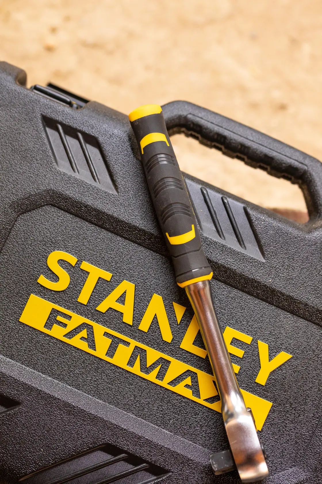Foto des STANLEY FMMT82827-1 Werkzeugkoffers mit einem schwarz-gelben Werkzeug darauf.