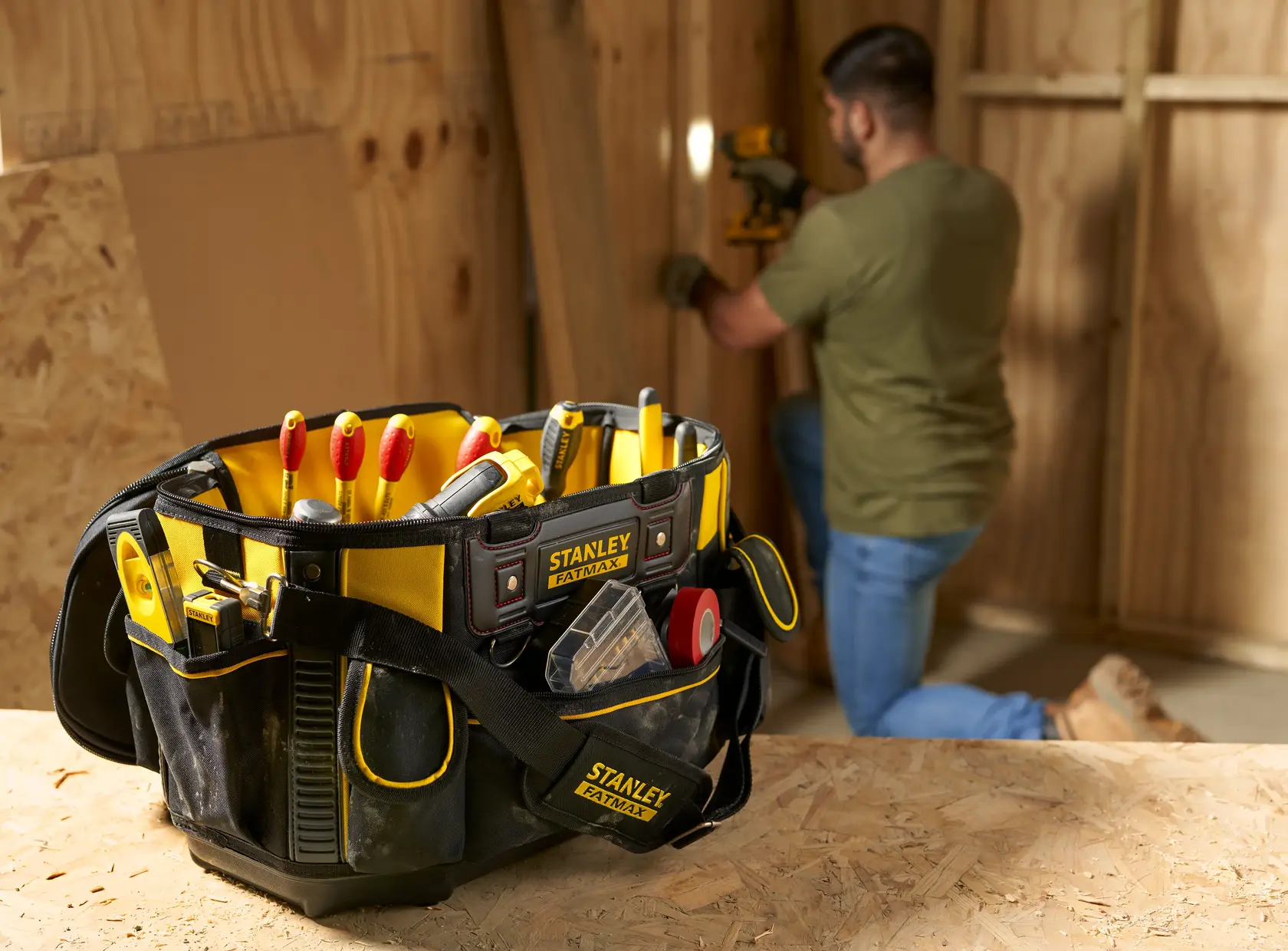 STANLEY FMST1-70749 Werkzeugtasche mit Handwerkzeugen auf Werkbank, Bauarbeiten im Hintergrund.