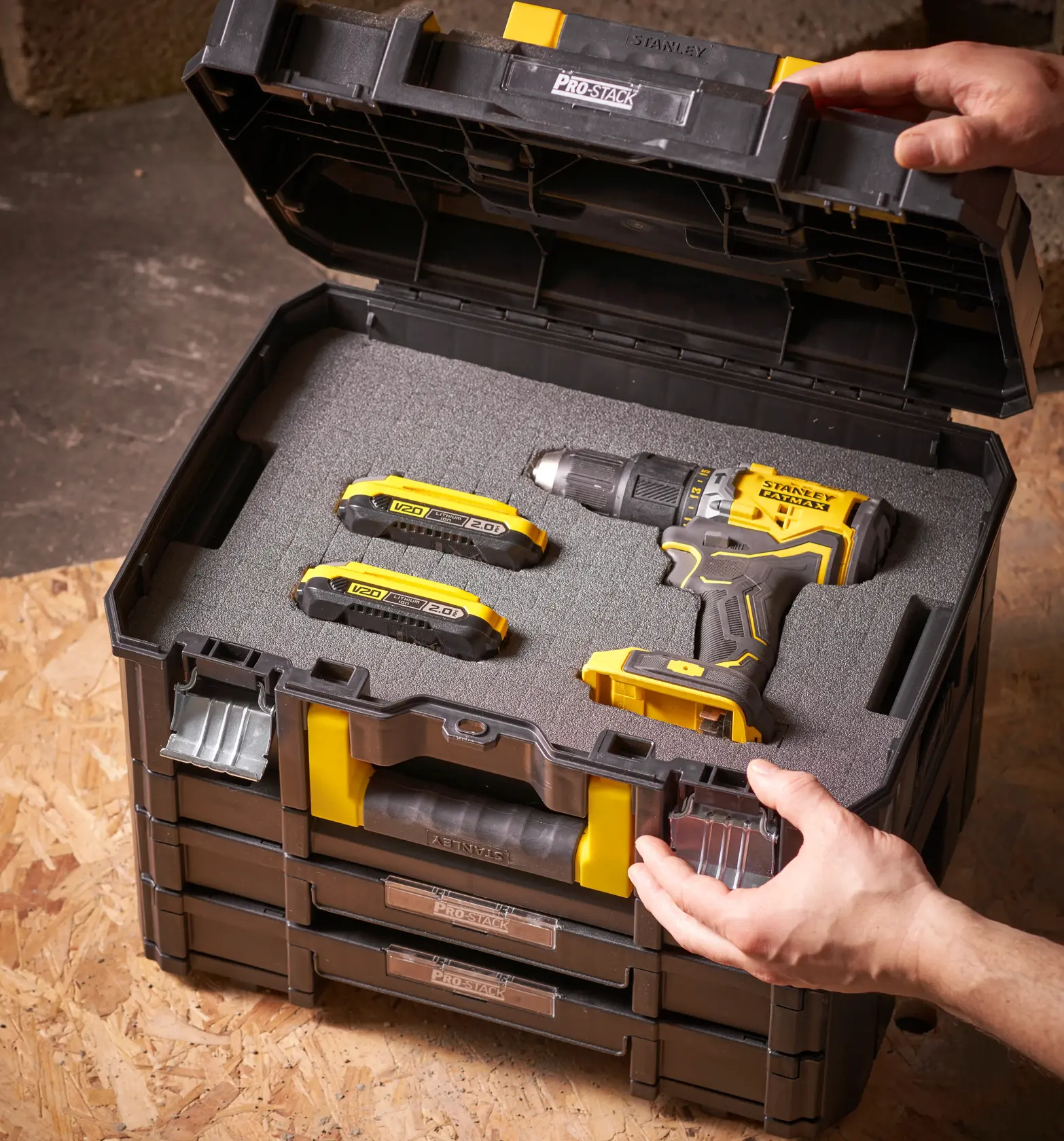 STANLEY FMST1-72365 ProStack Werkzeugkiste offen mit gelb-schwarzem Bohrer und zwei Batterien im Schaumeinsatz.
