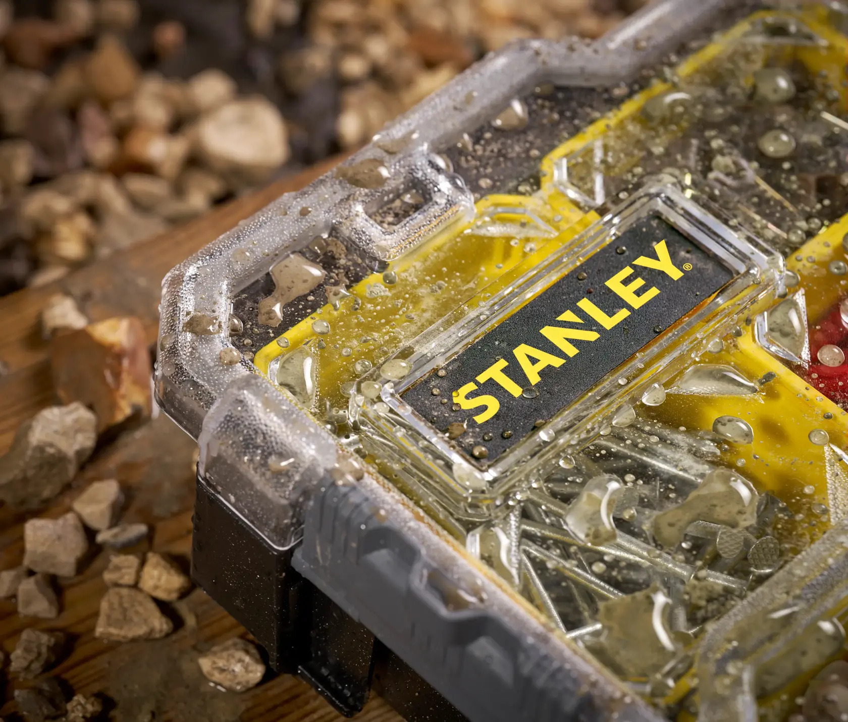 STANLEY FMST1-75779 Organizer mit Wassertropfen auf transparentem Deckel, Nahaufnahme, gelb-schwarzes Design.