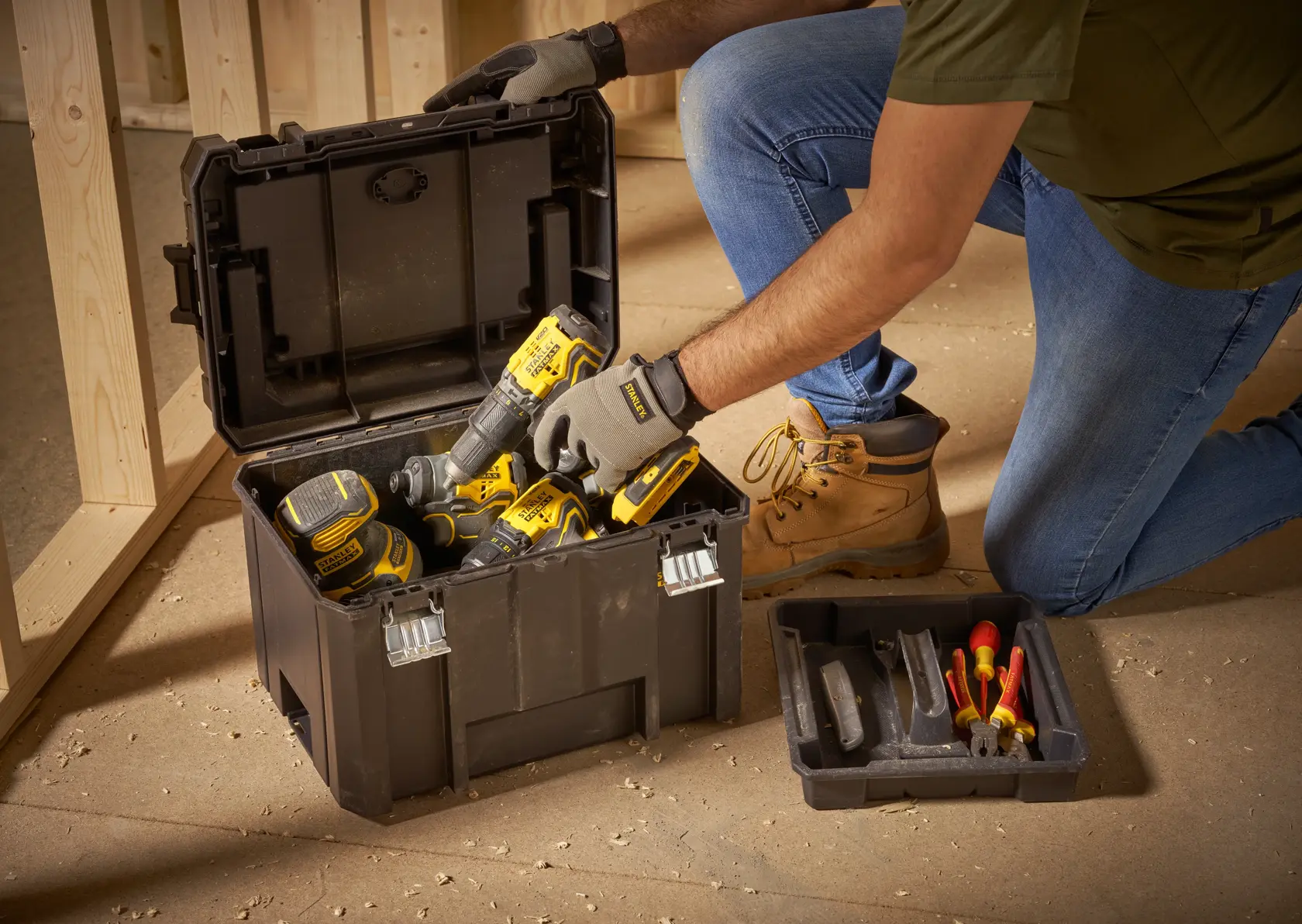STANLEY FMST1-75796 Werkzeugkasten offen, gefüllt mit Elektrowerkzeugen und Handwerkzeugen, Werkstatt innen.