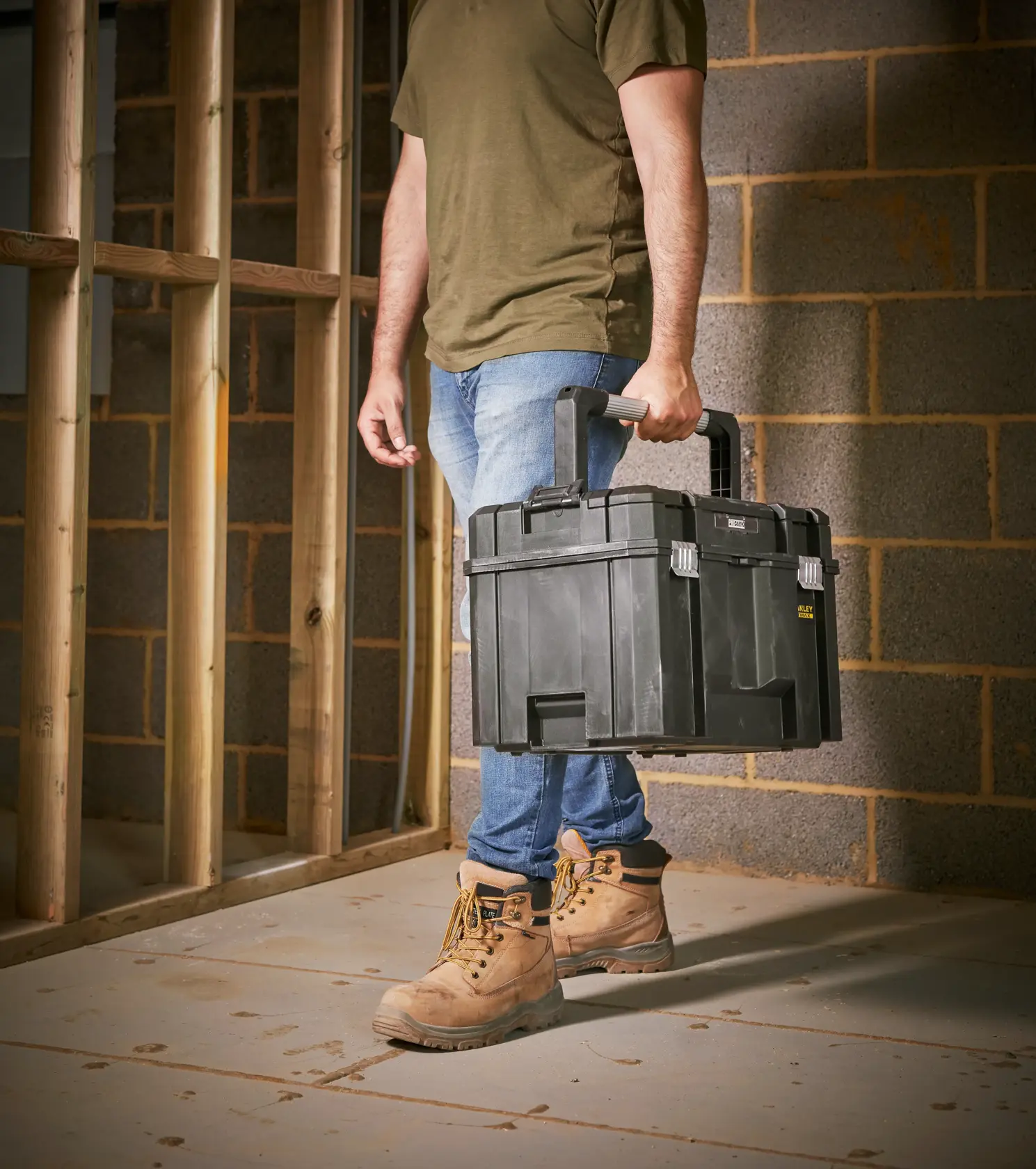 STANLEY FMST1-75796 schwarzer Werkzeugkasten von Person auf Baustelle getragen, Produktkategorie Fotografie.