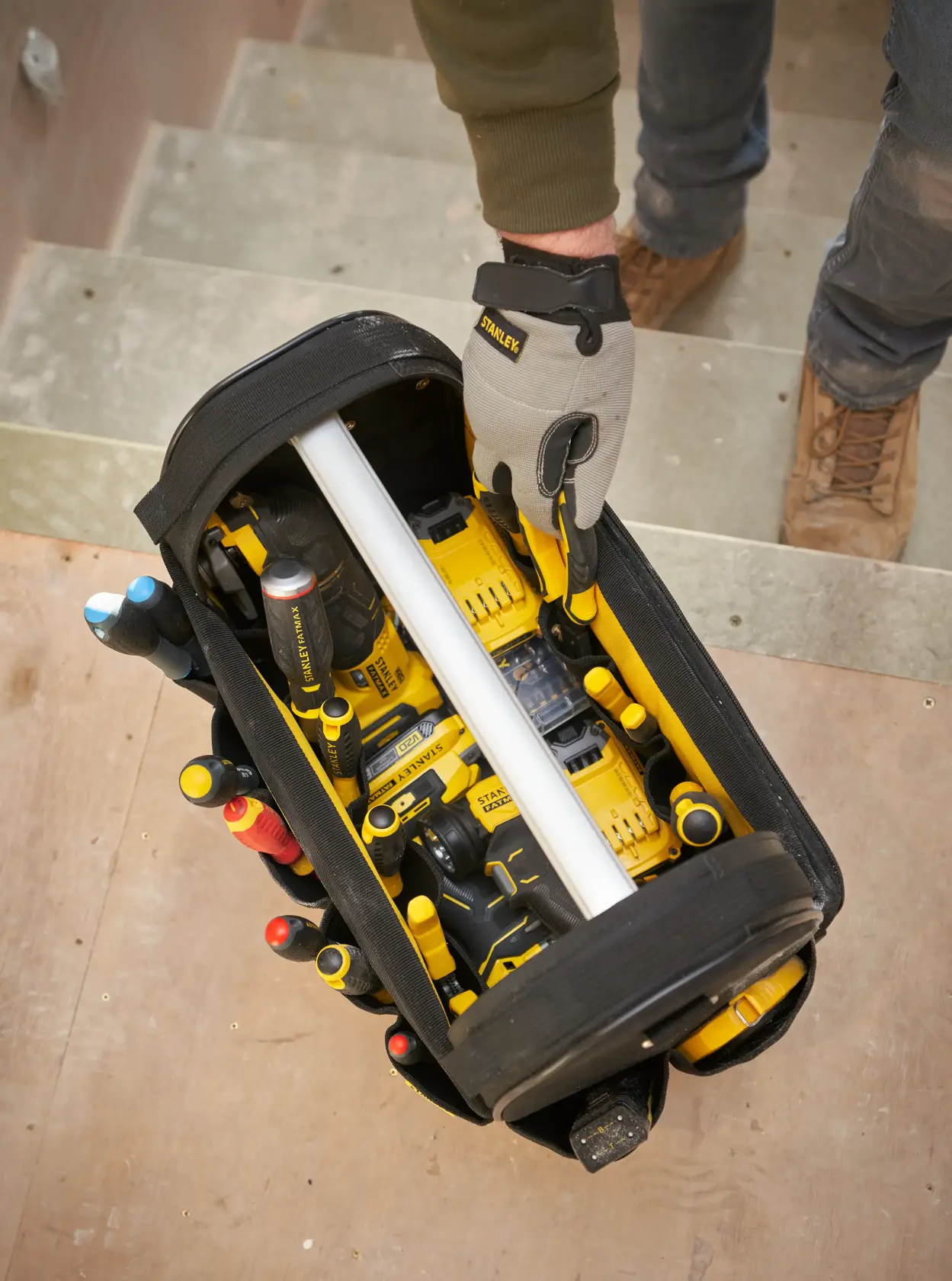 STANLEY FMST17626-1 Fotografie von offenem Werkzeugtasche mit gelbem Elektrowerkzeug und Handwerkzeugen von oben.
