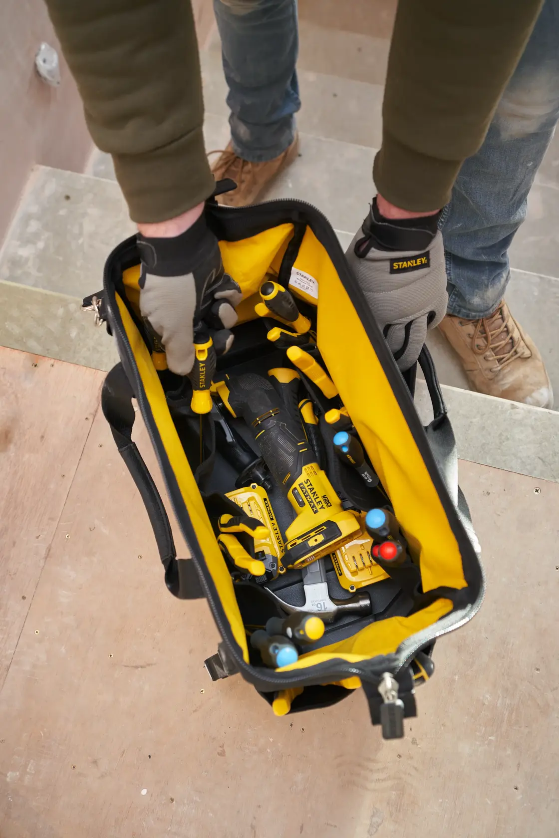 STANLEY FMST17627-1 Werkzeugtasche Draufsicht, gelb und schwarz, gefüllt mit Handwerkzeugen und Bohrer.