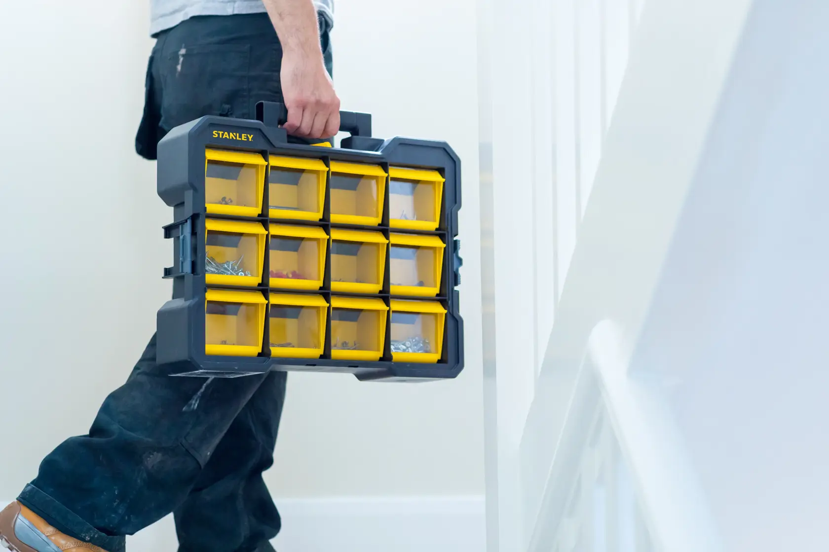 STANLEY FMST81077-1 Organizer mit gelben transparenten Fächern, wird drinnen in der Hand getragen.