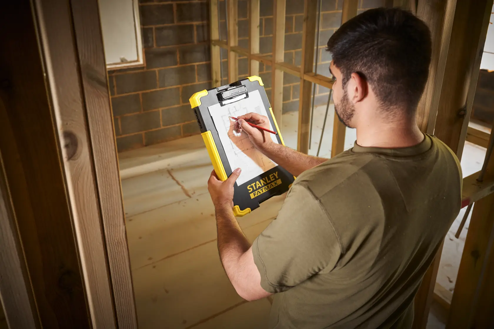 Foto des STANLEY FMST82721-1 Clipboards auf Baustelle, gelbes und schwarzes robustes Design.