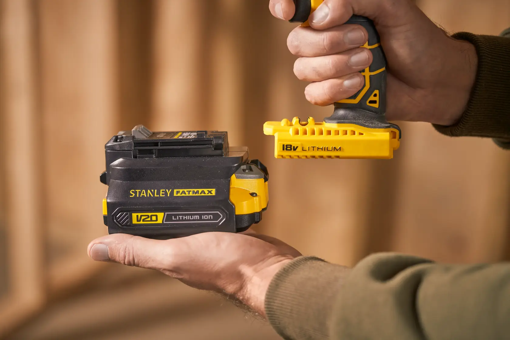 Foto von STANLEY SFMCB121D1 V20 Lithium-Ionen-Akku in der Hand gehalten, Nahaufnahme, gelbe und schwarze Details.
