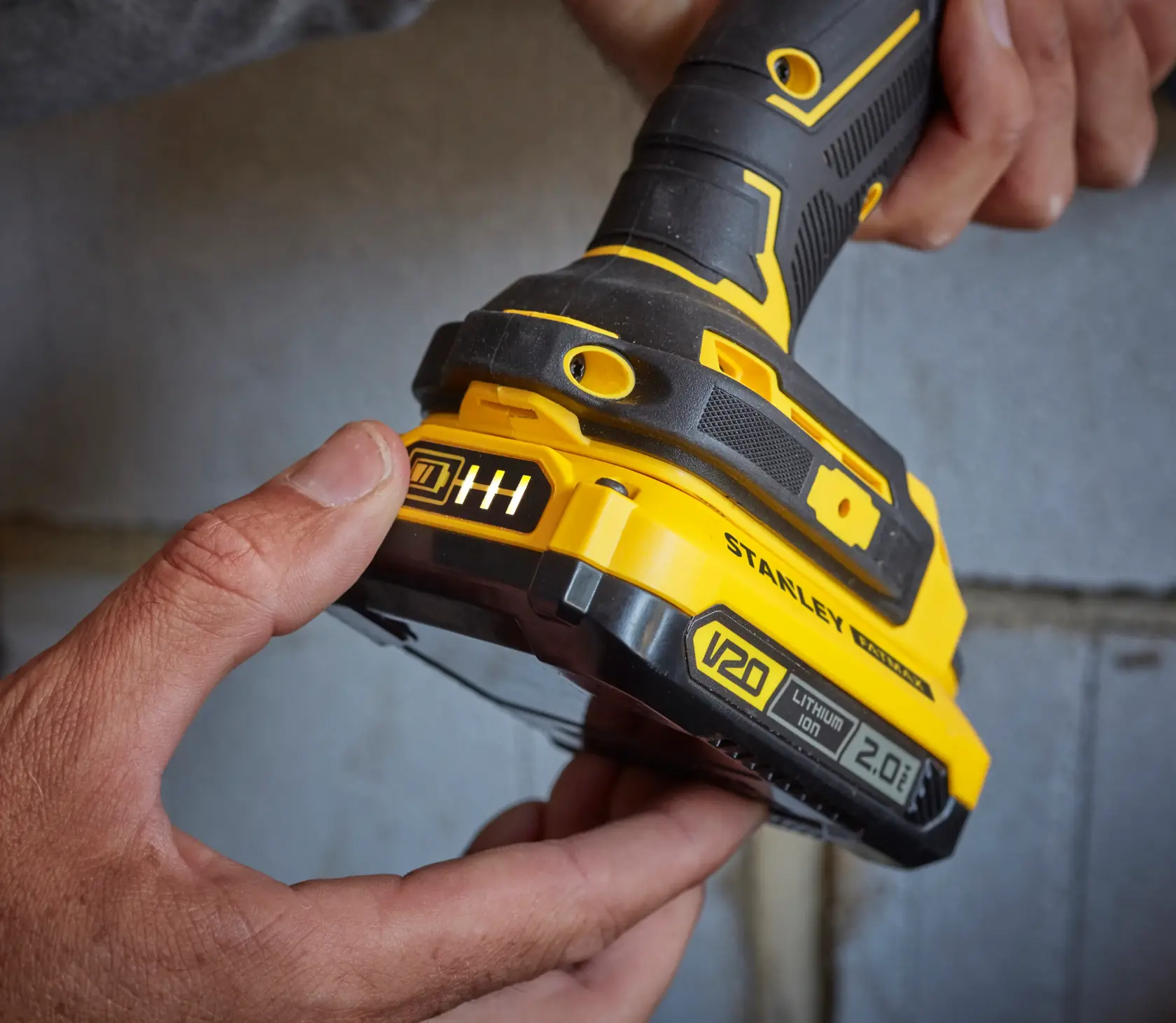 Foto der STANLEY SFMCB202 V20 Lithium Ion 2.0Ah Batterie an gelb-schwarzem Elektrowerkzeug.