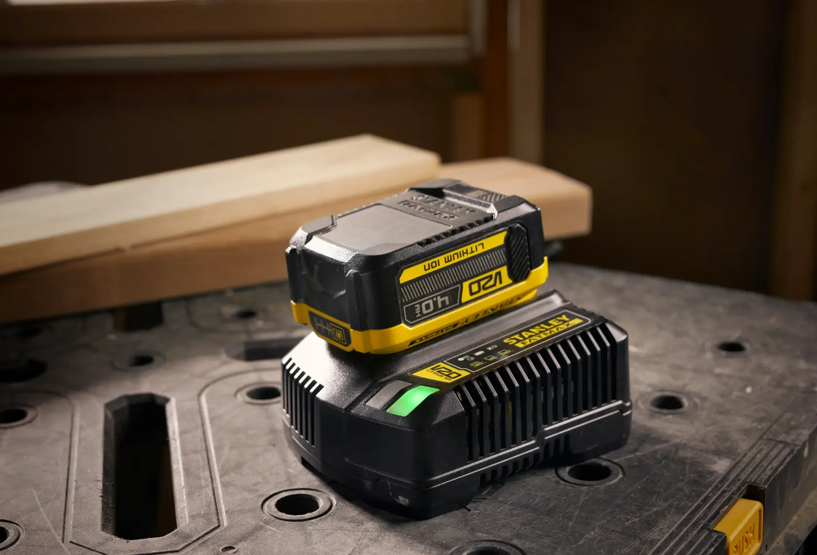STANLEY SFMCB204 Akku und Ladegerät, schwarz und gelb, auf Werkstatttisch, Produktfotografie.