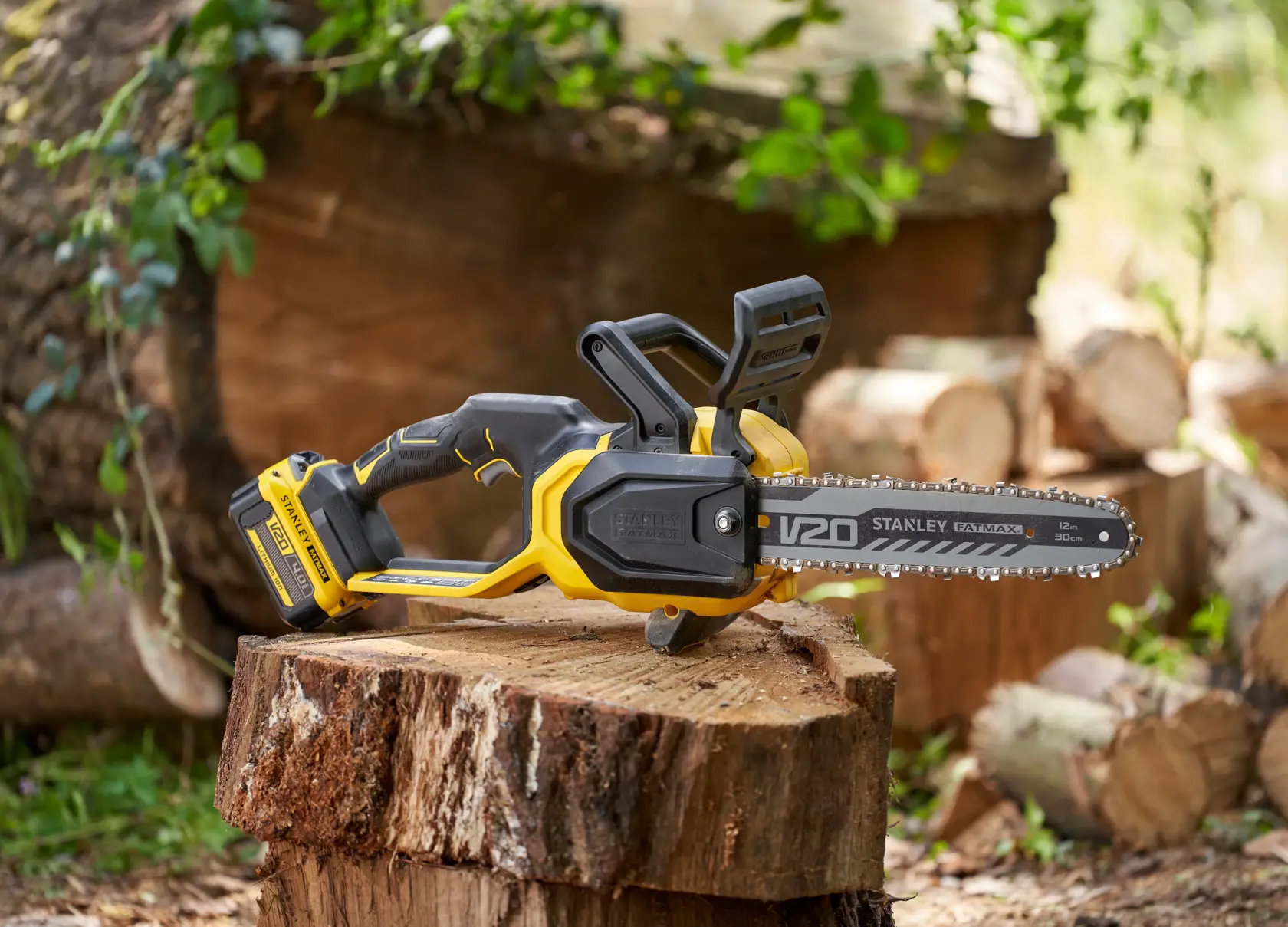 STANLEY SFMCCS730B kabellose Kettensäge in Gelb und Schwarz auf Baumstumpf im Freien.