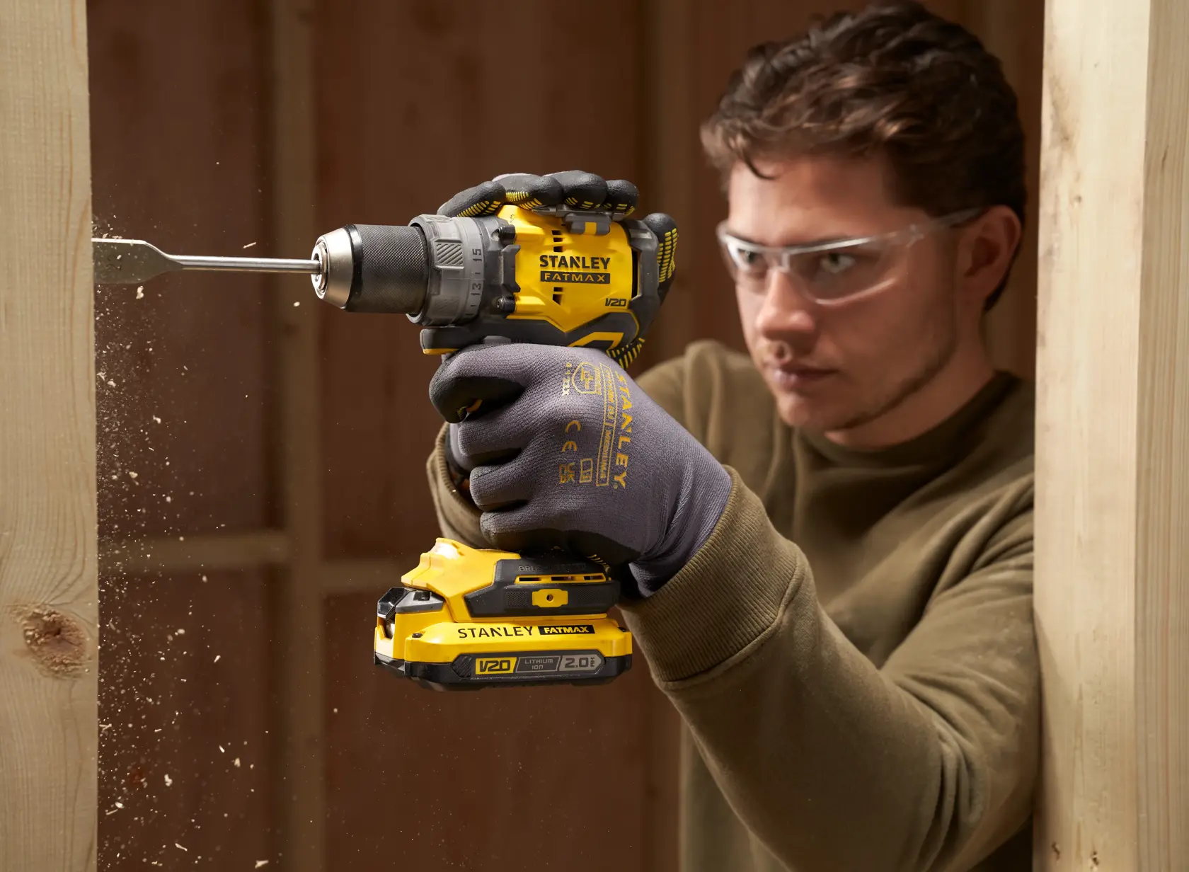 Foto des STANLEY SFMCD725D2K Akku-Bohrers beim Bohren durch Holz, Nahaufnahme.