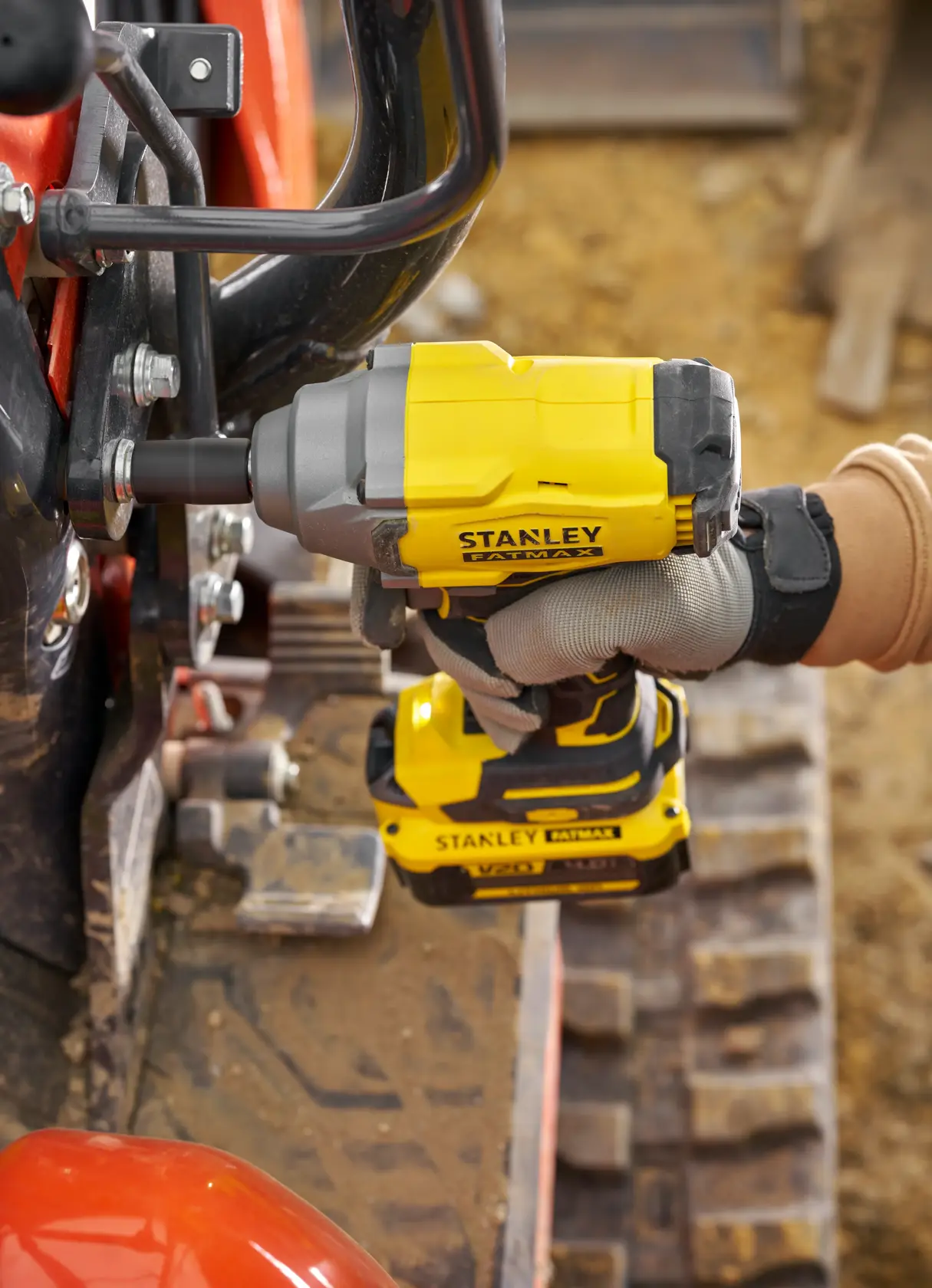 STANLEY SFMCF920B Schlagschrauber im Einsatz, Seitenansicht, gelb und schwarz, schraubt Bolzen an Maschine.