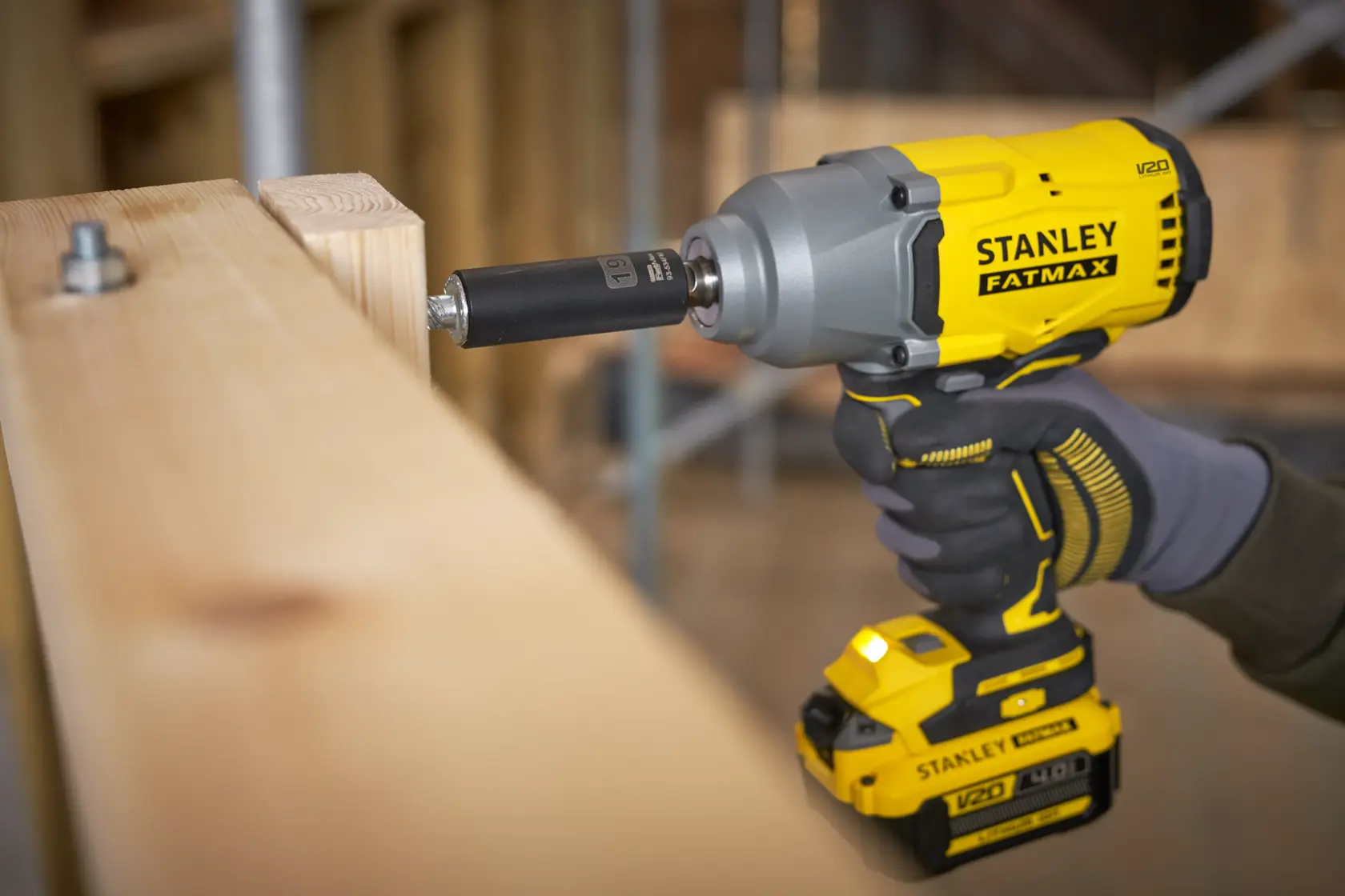 Foto des STANLEY SFMCF940B Akku-Schlagschraubers beim Befestigen einer Schraube in Holzbalken.