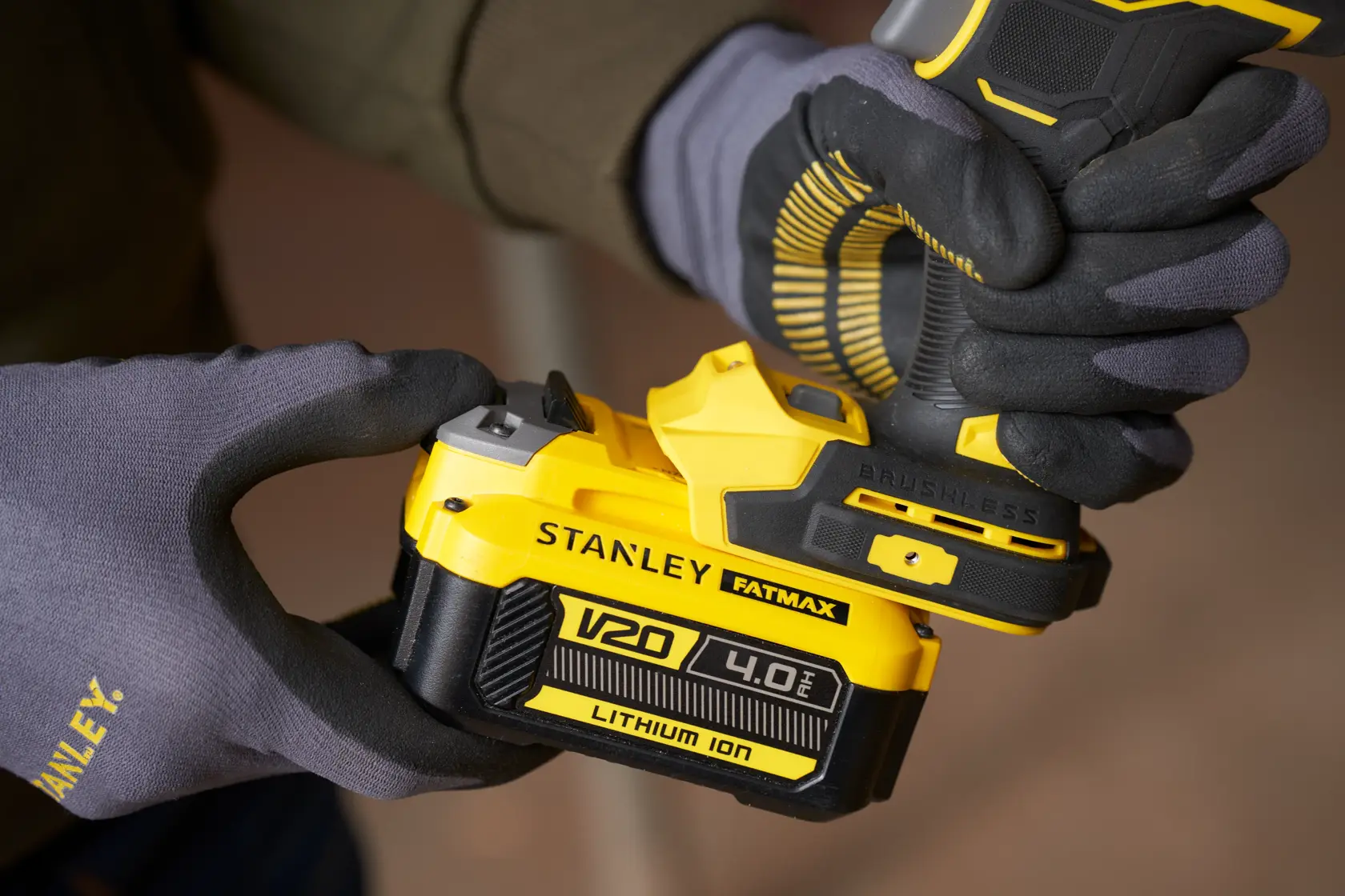 Foto des STANLEY SFMCF940B V20 4,0Ah Lithium-Ionen-Akkus, der an ein kabelloses Werkzeug angebracht wird, Nahaufnahme.