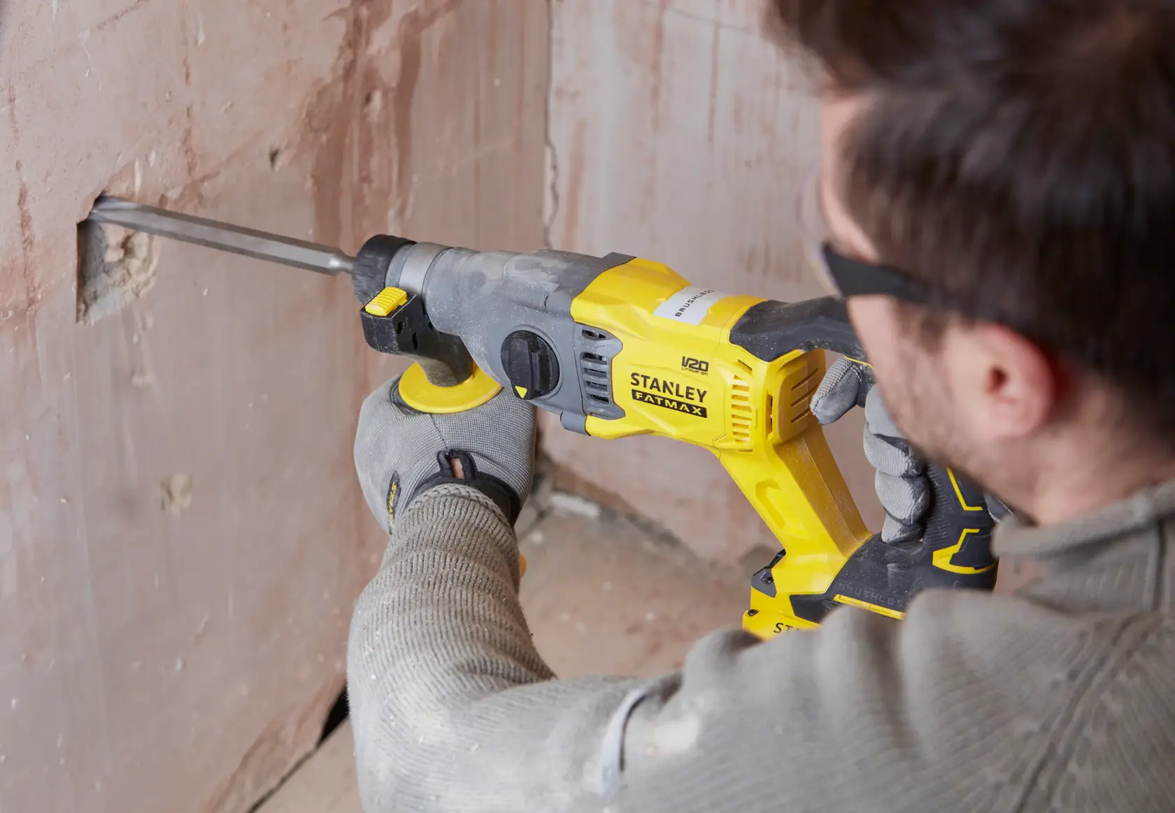 Foto des STANLEY SFMCH900M12 Bohrhammers im Einsatz an einer Gipswand auf Baustelle.