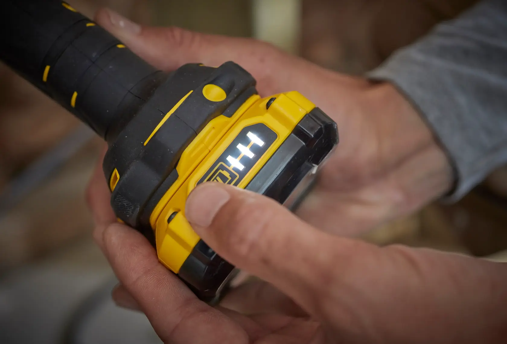 STANLEY SFMCL020B gelb-schwarzer Werkzeugakku mit LED-Anzeige, Nahaufnahme in der Hand.