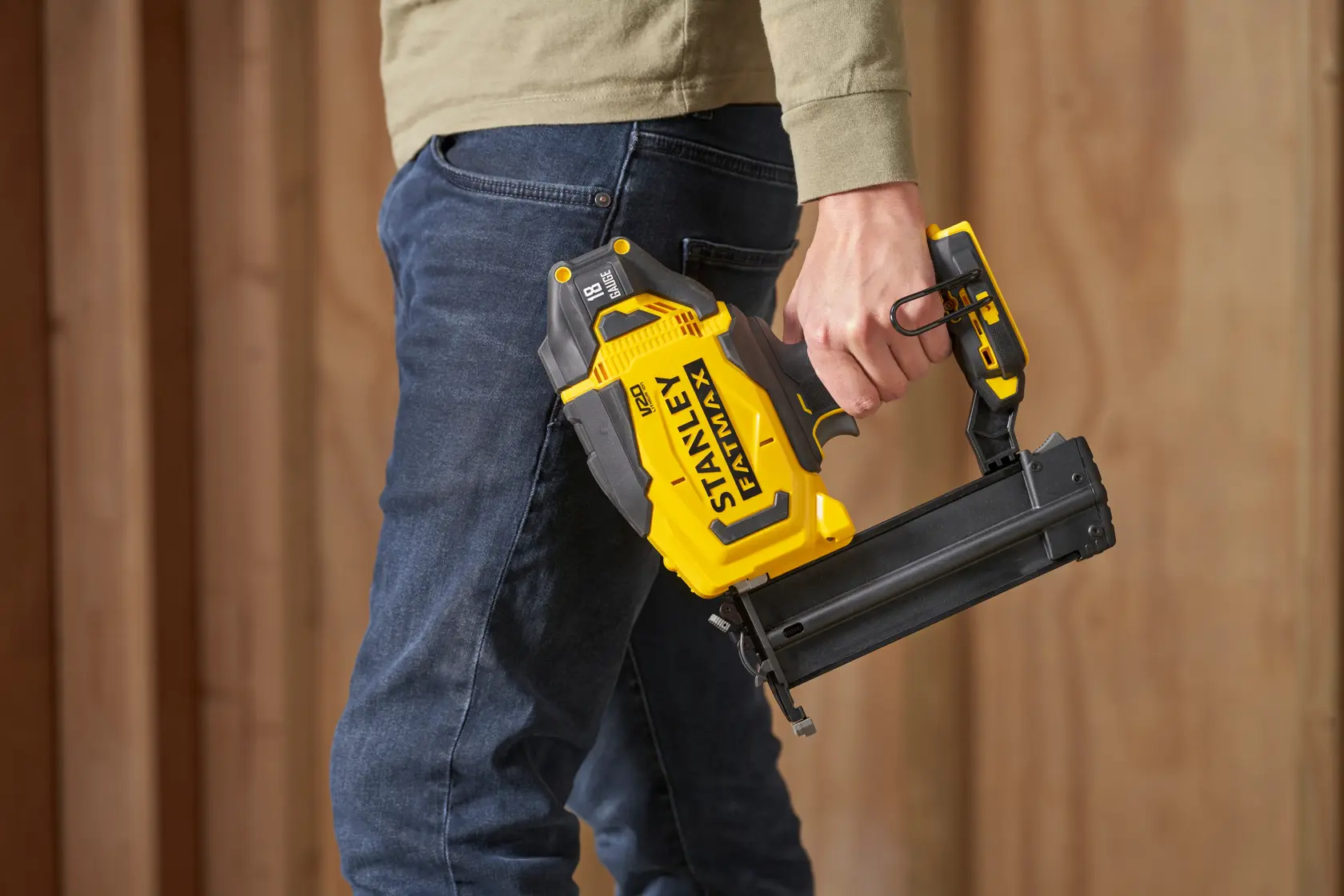 Foto der kabellosen gelben Nagelpistole STANLEY SFMCN618B-XJ, in der Hand gehalten, Seitenansicht.