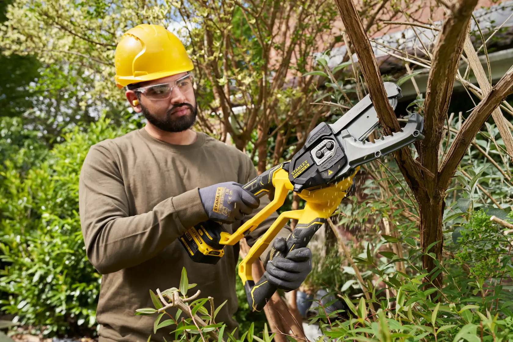 STANLEY SFMCPS515B kabellose Astsäge im Einsatz, schneidet Äste im Freien.