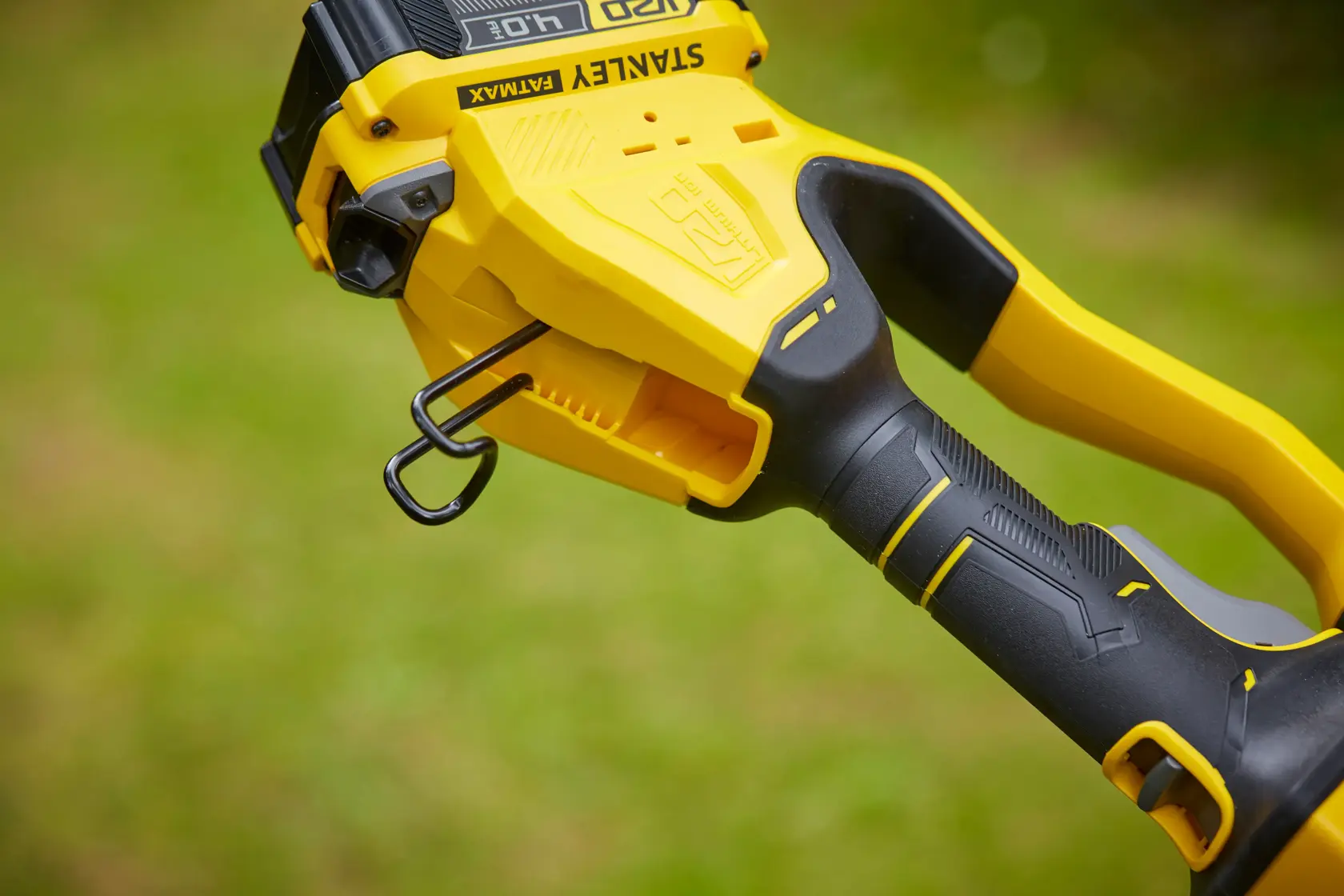Foto des schwarzen und gelben ergonomischen Griffs der STANLEY SFMCPS620M1 Kettensäge, Seitenansicht im Freien.