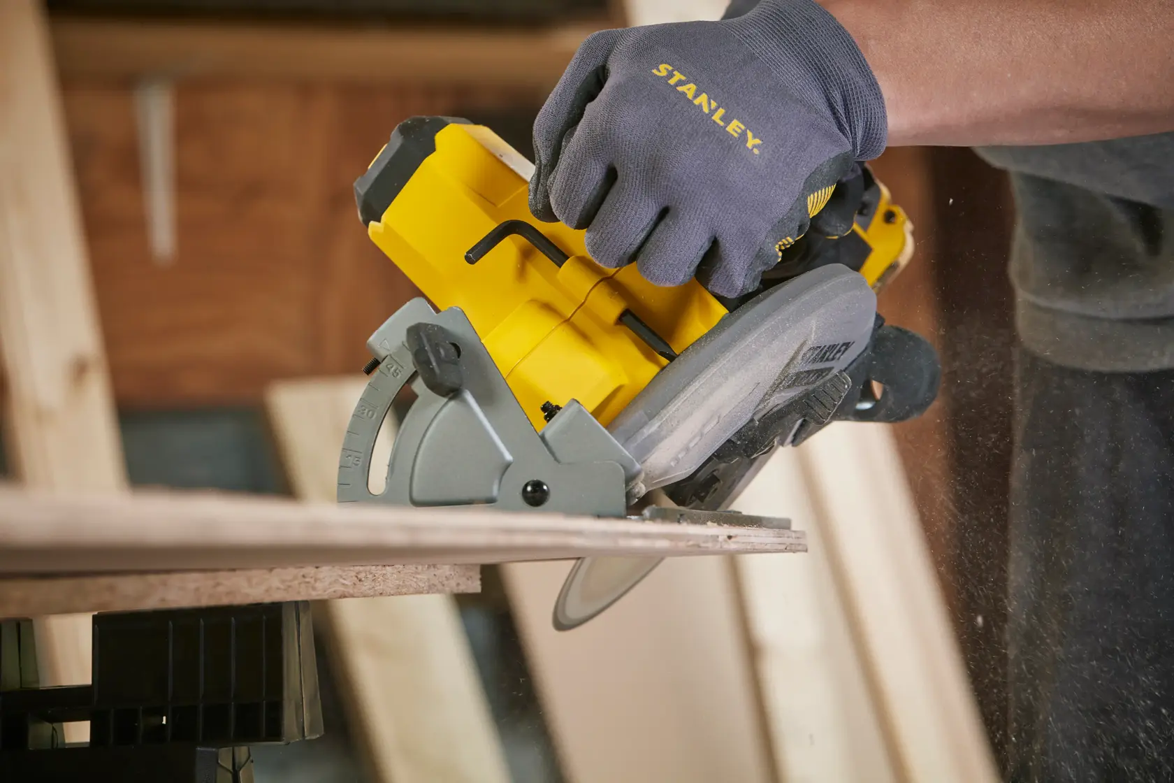 Stanley SFMCS500B Kreissäge im Einsatz, Holz sägend, Nahaufnahme seitlich, gelbes und graues Werkzeug.