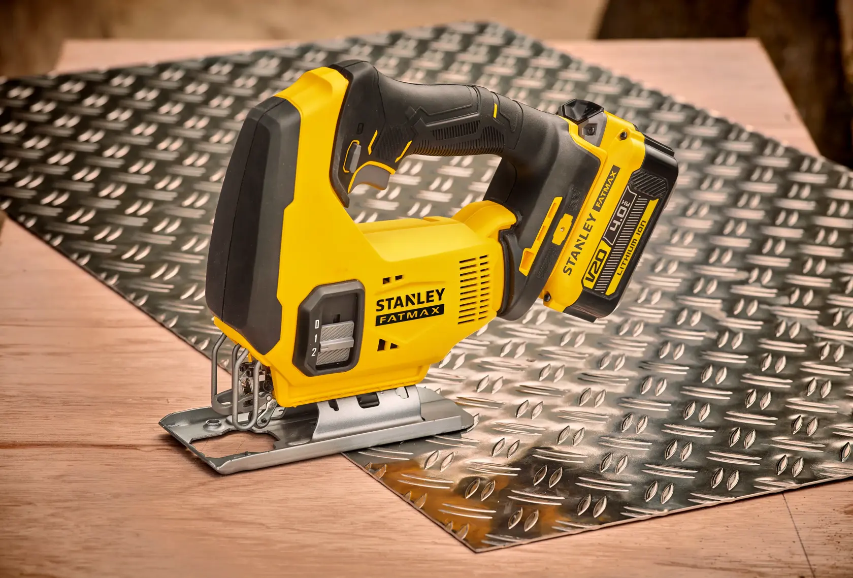 STANLEY SFMCS600M2K Stichsäge auf Riffelblech, gelb-schwarzes Design, Seitenansicht.