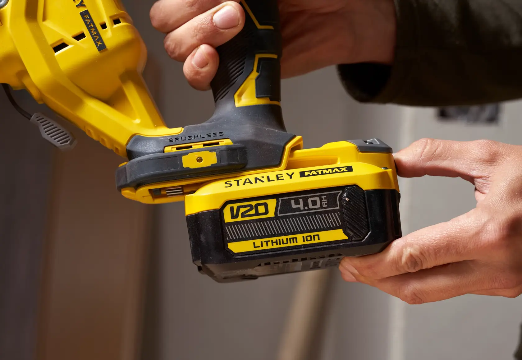 Foto von STANLEY SFMCS650B 18V FATMAX V20 Brushless Stichsäge in Hand, Nahaufnahme der V20 Lithium-Ion-Batterie.