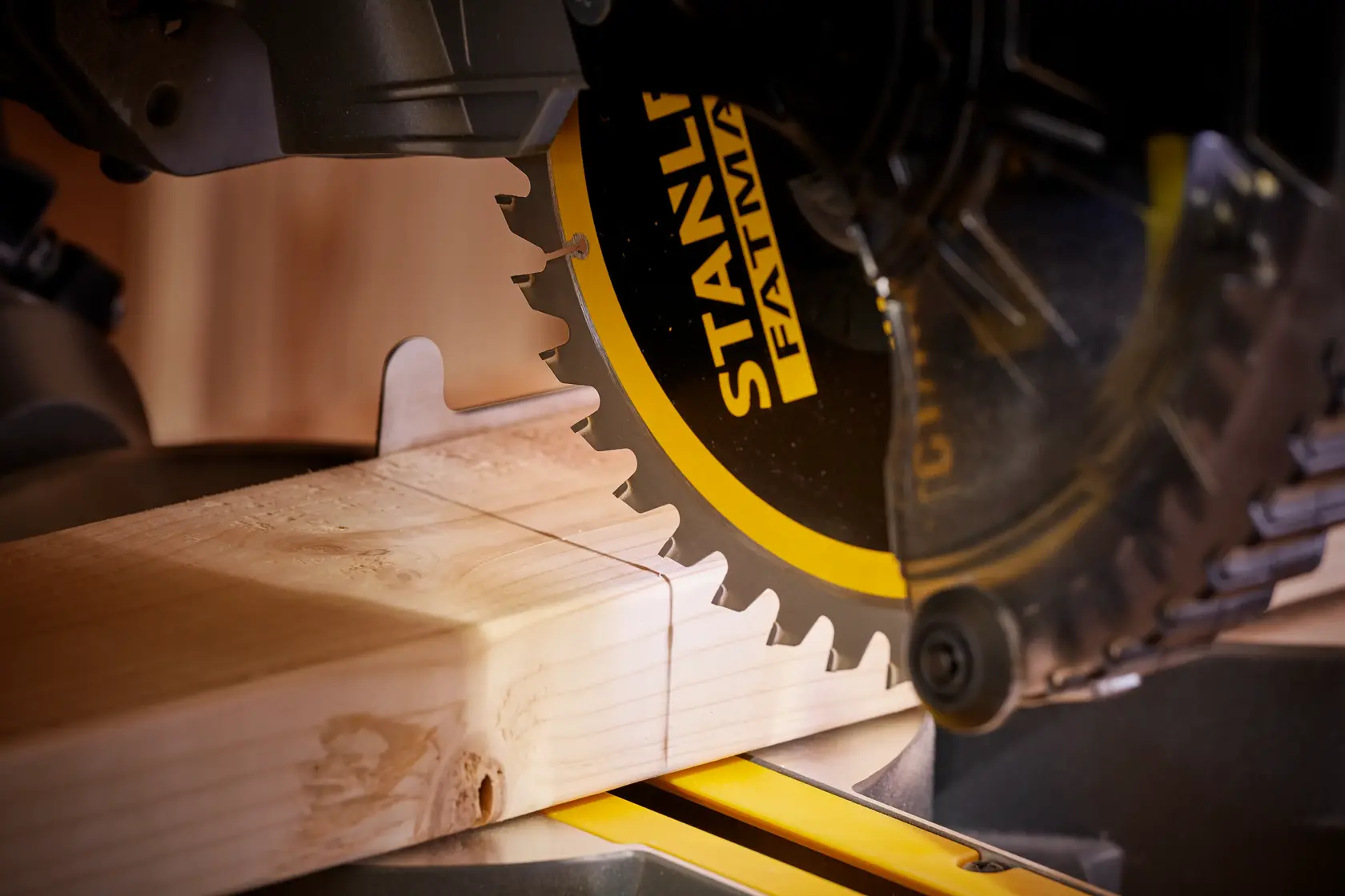 STANLEY SFMCS701M1 Kappsäge Nahaufnahme beim Schneiden von Holz, schwarz-gelbes Sägeblatt, Holzverarbeitung.