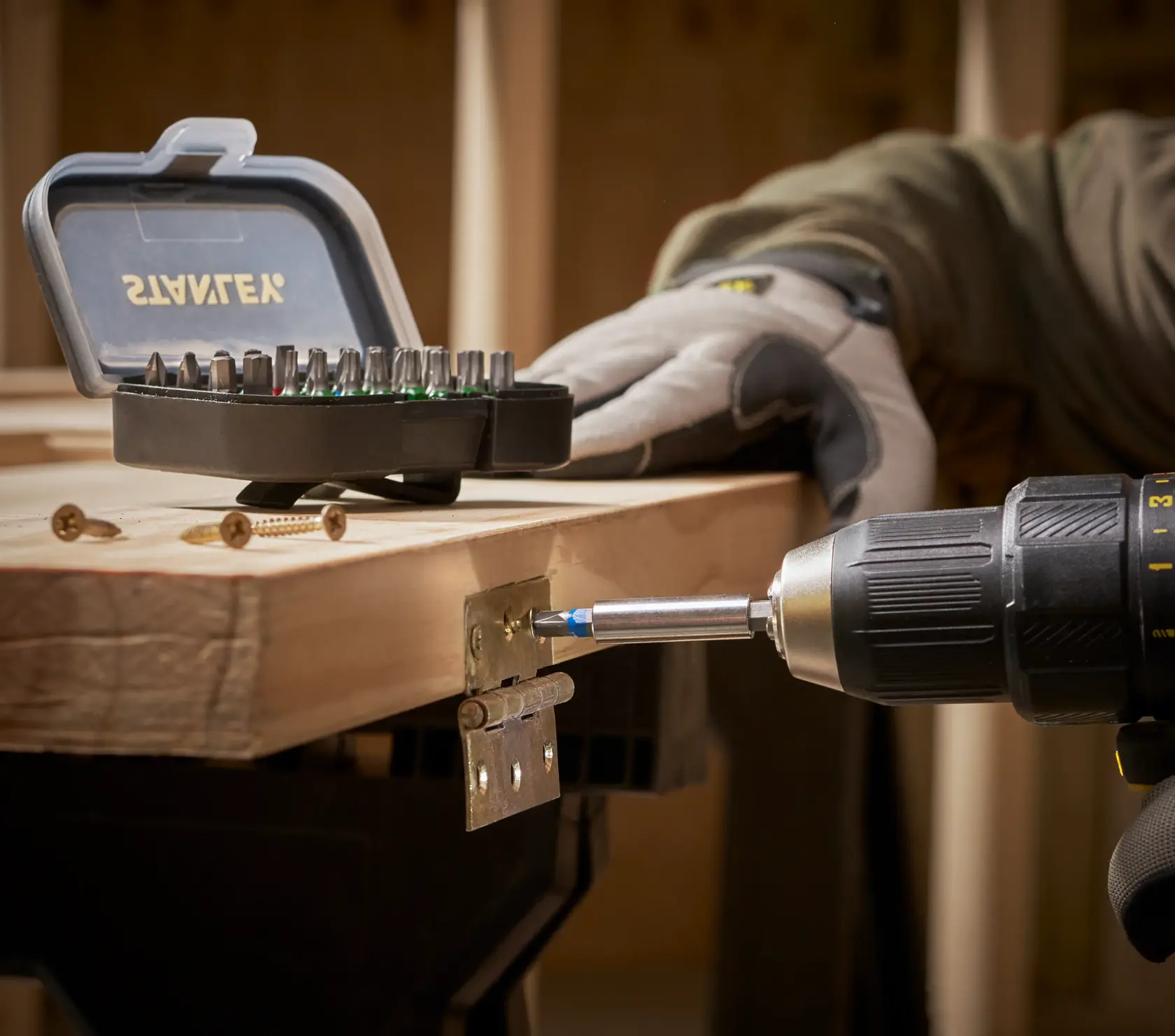 STANLEY STA60490 Bit-Set in offener Box auf Tisch, mit Bohrer und angeschraubtem Scharnier.