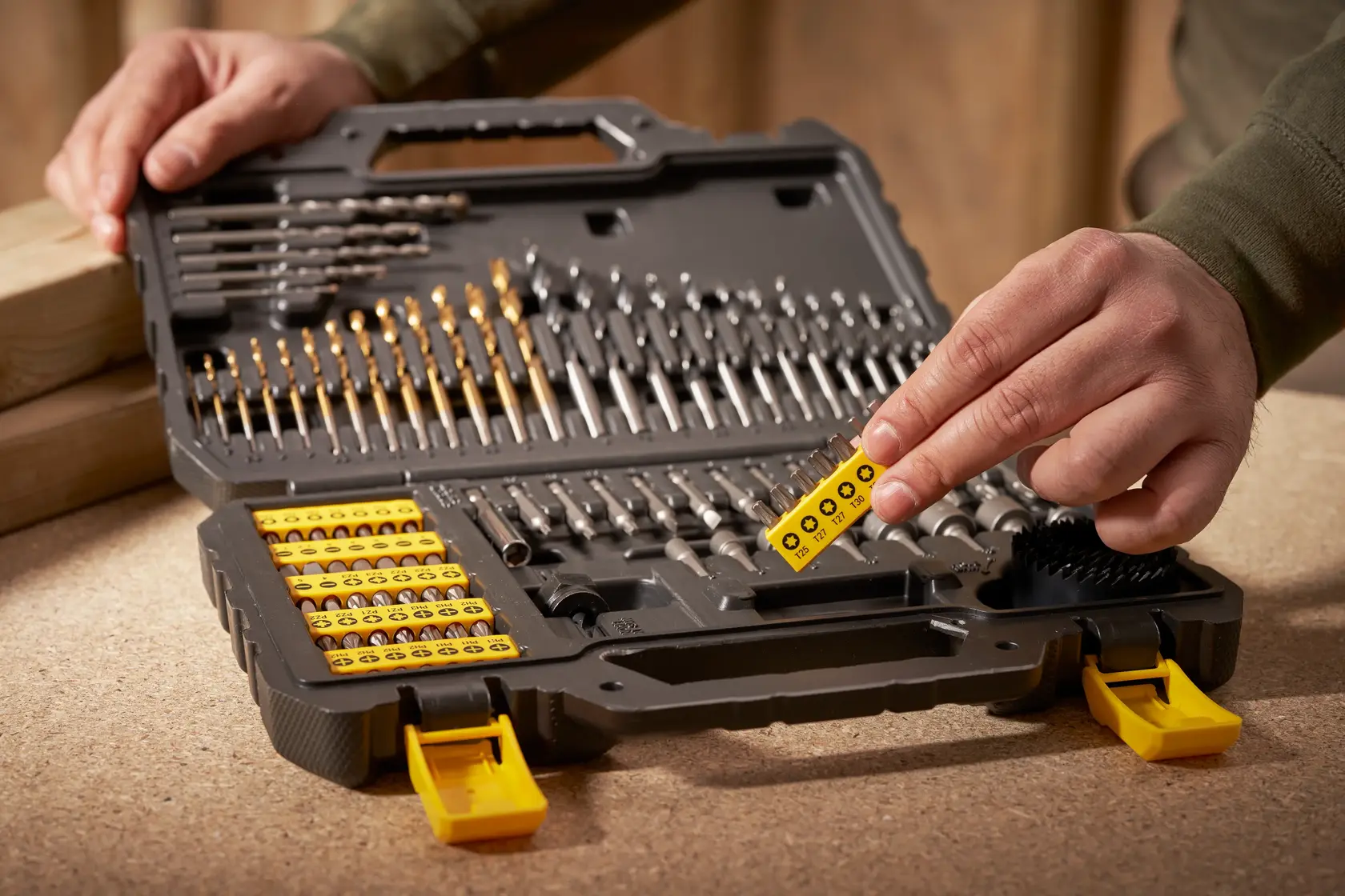 STANLEY STA88548 Bohr- und Schrauber-Bit-Set im offenen Koffer, Hand wählt gelben Bit-Halter.