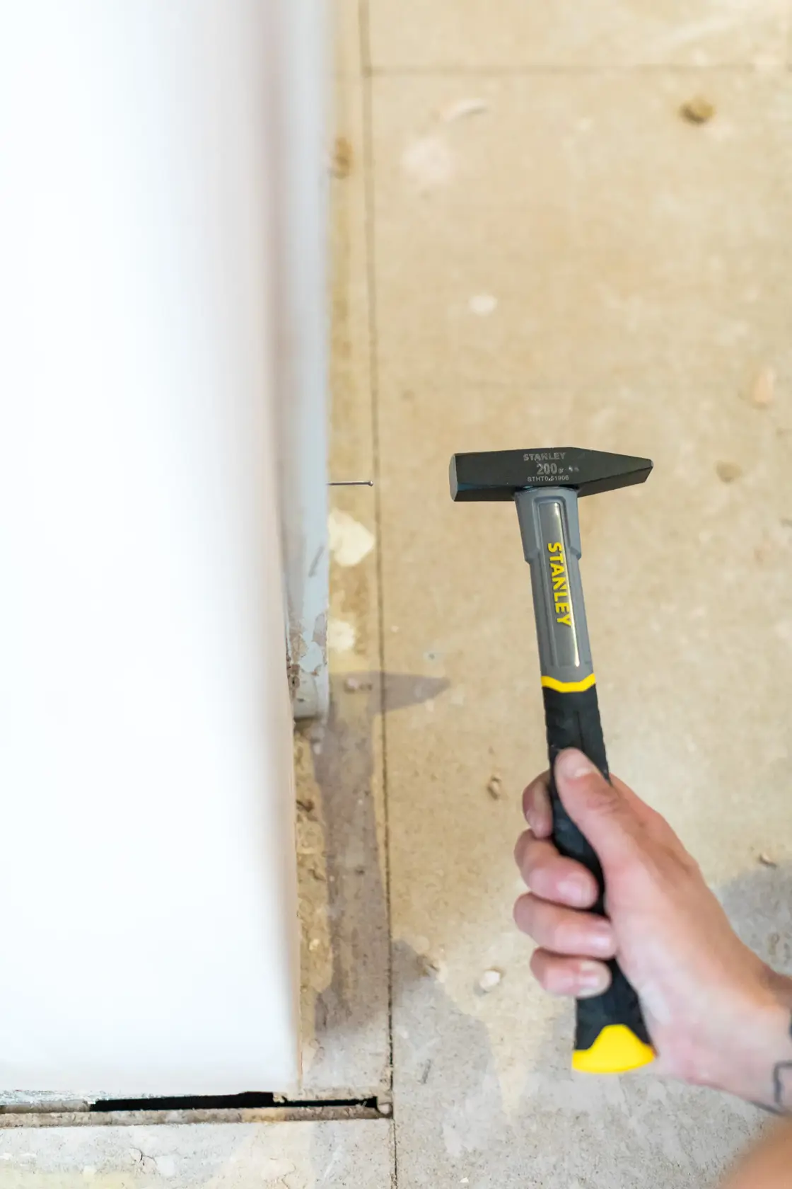 STANLEY STHT0-51906 Hammer mit schwarz-gelbem Griff, in der Hand gehalten, Innenbauumgebung.