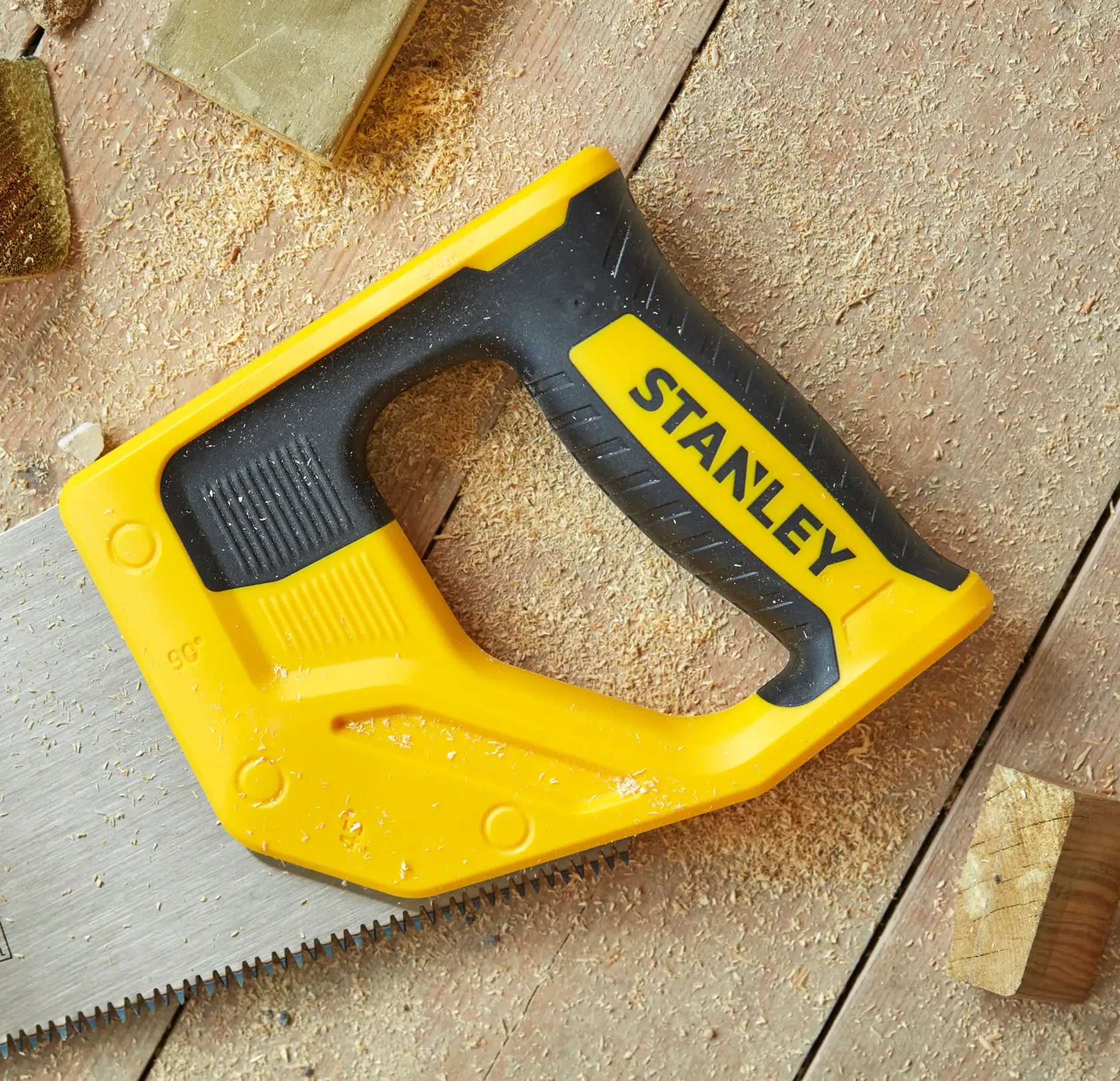 STANLEY STHT20350-1 Handsäge mit gelbem und schwarzem Griff, Fotografie auf Holzoberfläche mit Sägemehl.