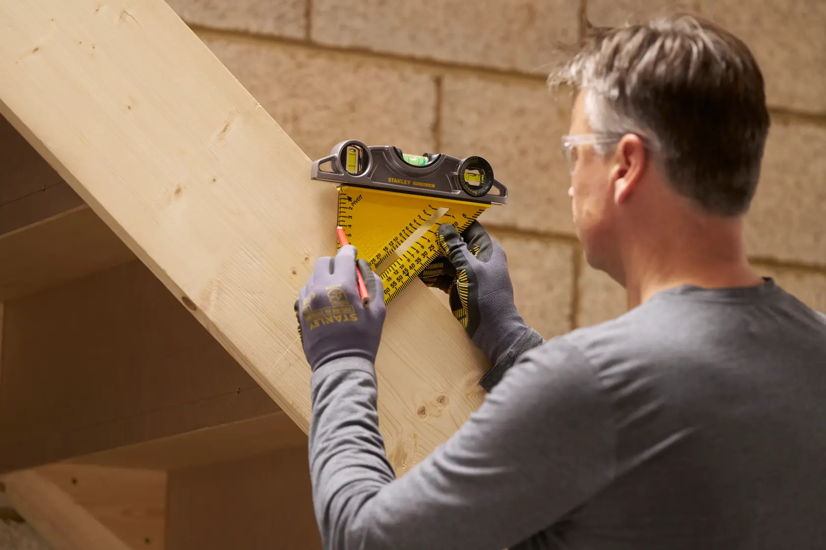 STANLEY STHT46012-0 Zimmermannswinkel mit Libelle zum Anzeichnen von Maßen auf einem Holzbalken.