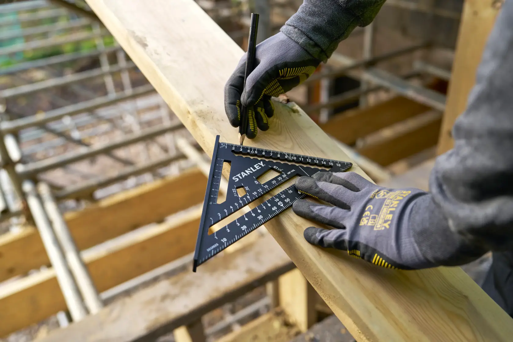STANLEY STHT46101-0 Zimmermannswinkel zum Anzeichnen auf Holz, behandschuhte Hände, Außenbaustelle.