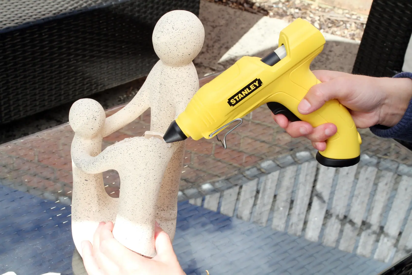 Stanley STHT6-70416 gelbe Klebepistole bei Skulptur, Seitenansicht, Produktfotografie.