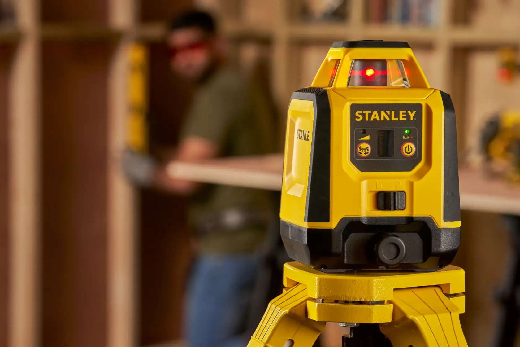Foto des gelben STANLEY STHT77616-0 Laser-Nivelliergeräts auf Stativ für Bauausrichtung.