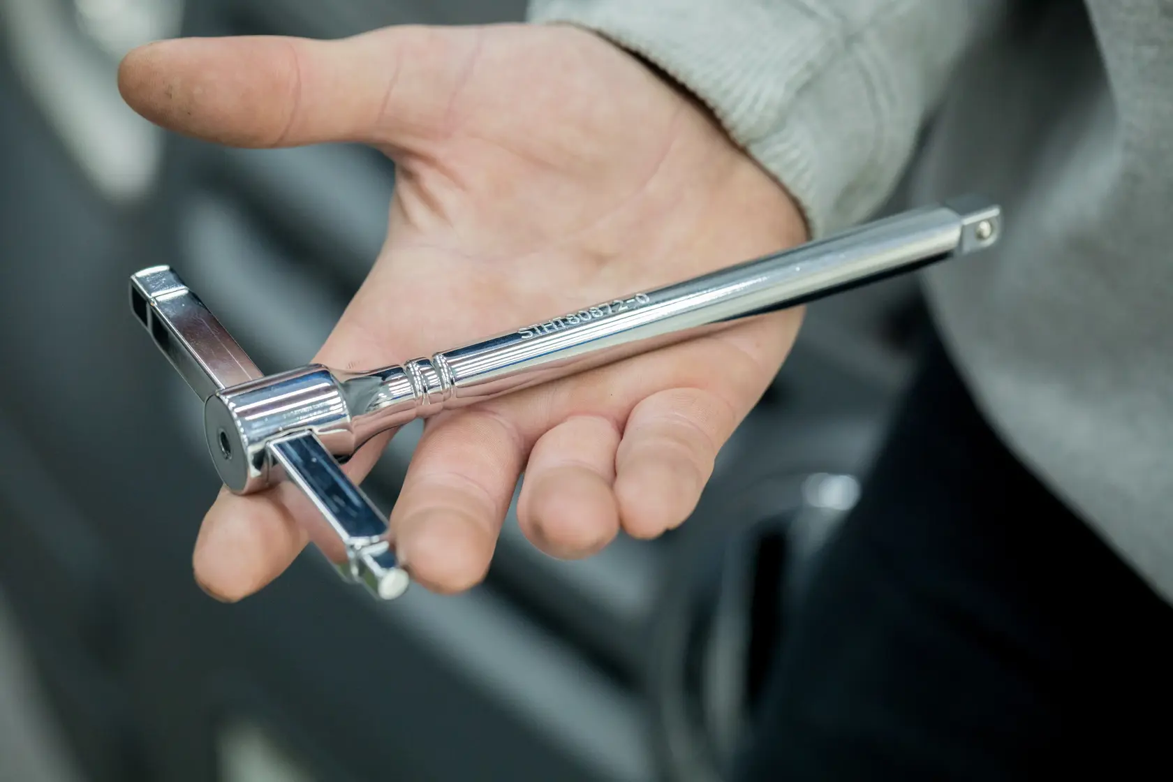 STANLEY STHT80872-0 verchromter T-Griff-Gewindebohrer in der Hand, Nahaufnahmefotografie.