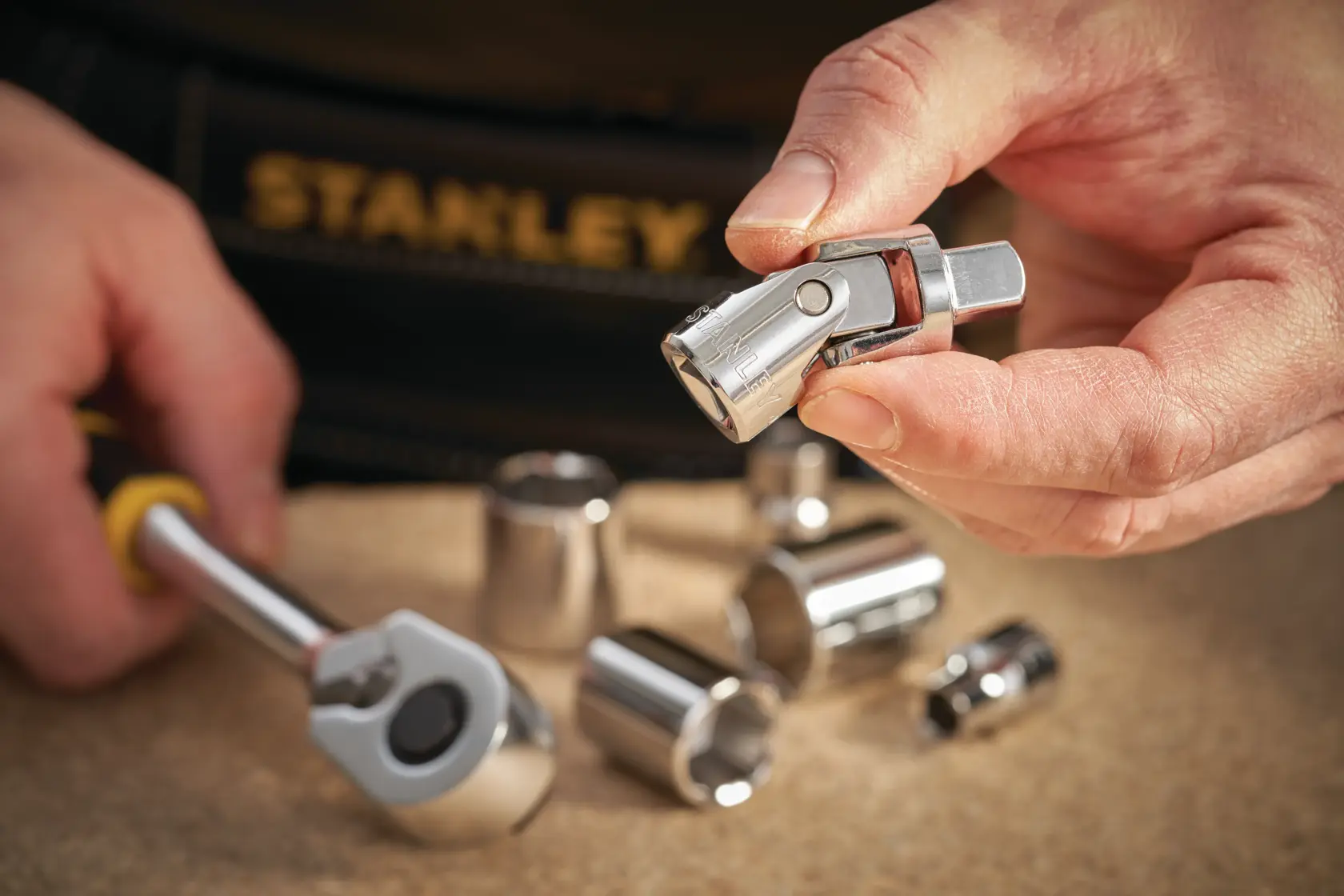 STANLEY STMT86211-0 Stecknuss- und Adapter-Set in Hand gehalten, Nahaufnahme auf Werkbank.