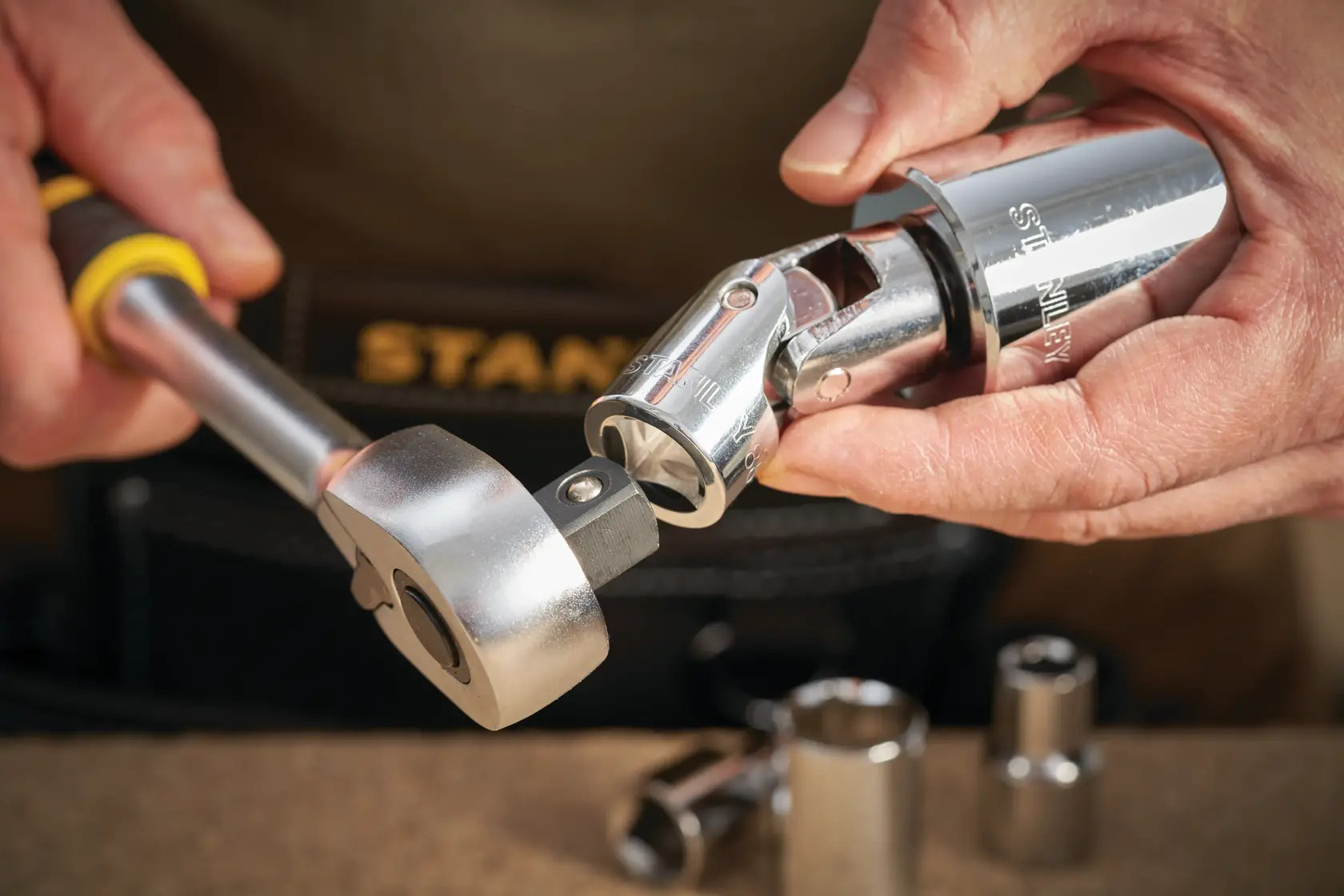 STANLEY STMT86411-0 Ratschen- und Steckschlüsselsatz in Anwendung, Nahaufnahme der Hand mit Werkzeug.