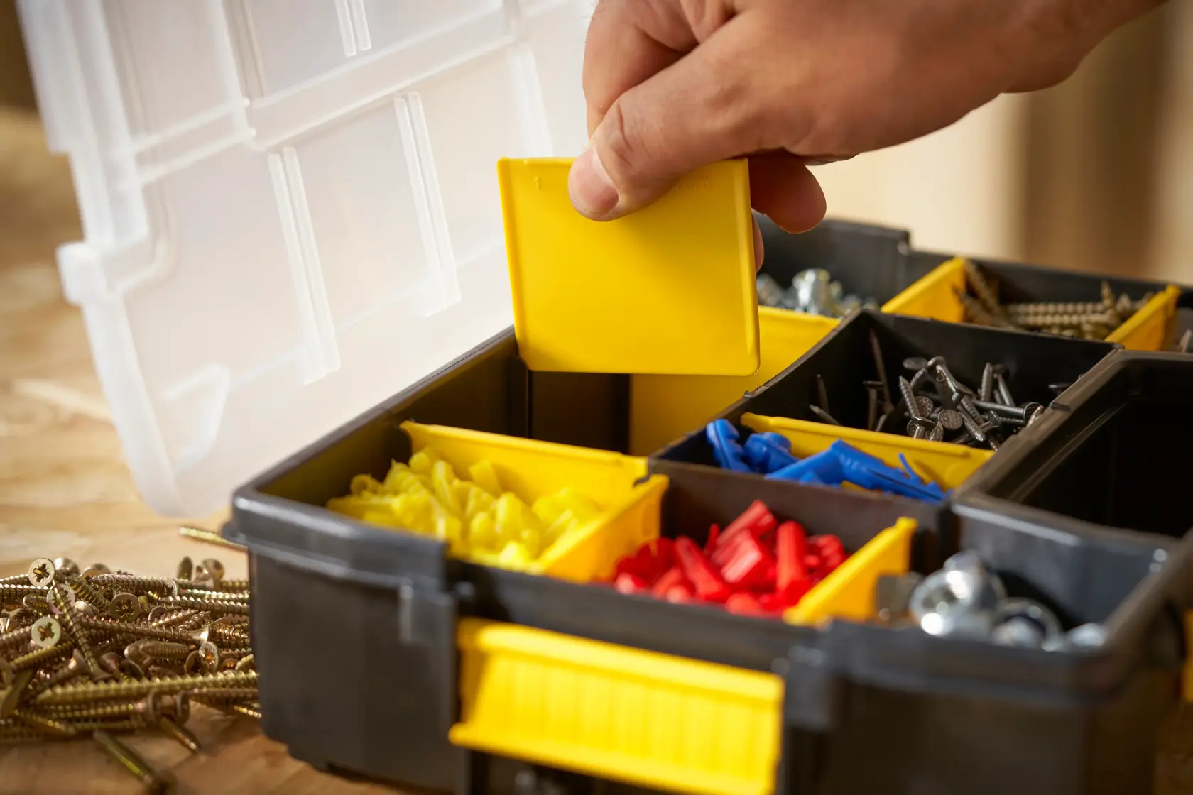 STANLEY STST1-70720 Organizer-Box mit gelben, roten, blauen Fächern, Hand hebt Trennwand, vorne.