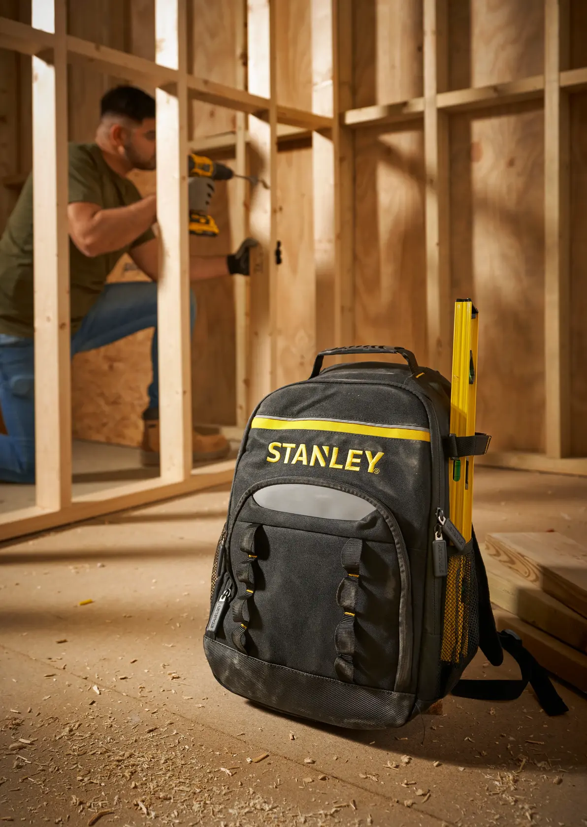 Foto des STANLEY STST1-72335 Werkzeugrucksacks mit gelbem Detail auf Baustelle, Vorderansicht.
