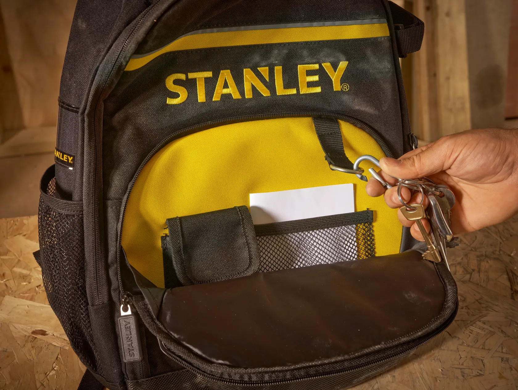 STANLEY STST1-72335 schwarz-gelber Rucksack, Fronttasche mit Schlüsseln am Clip, Nahaufnahme.