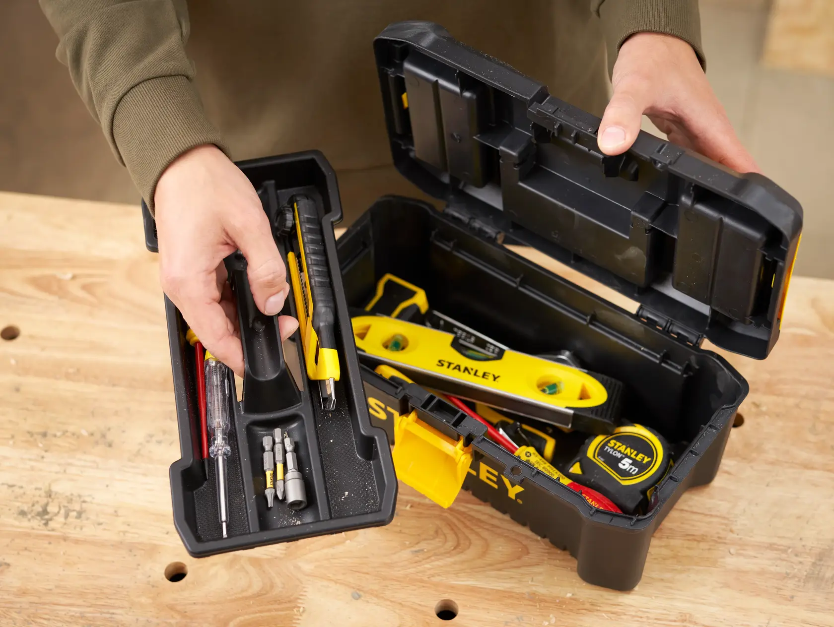 STANLEY STST1-75514 Werkzeugkasten offen auf Holztisch, Handwerkzeuge und Zubehör sichtbar.