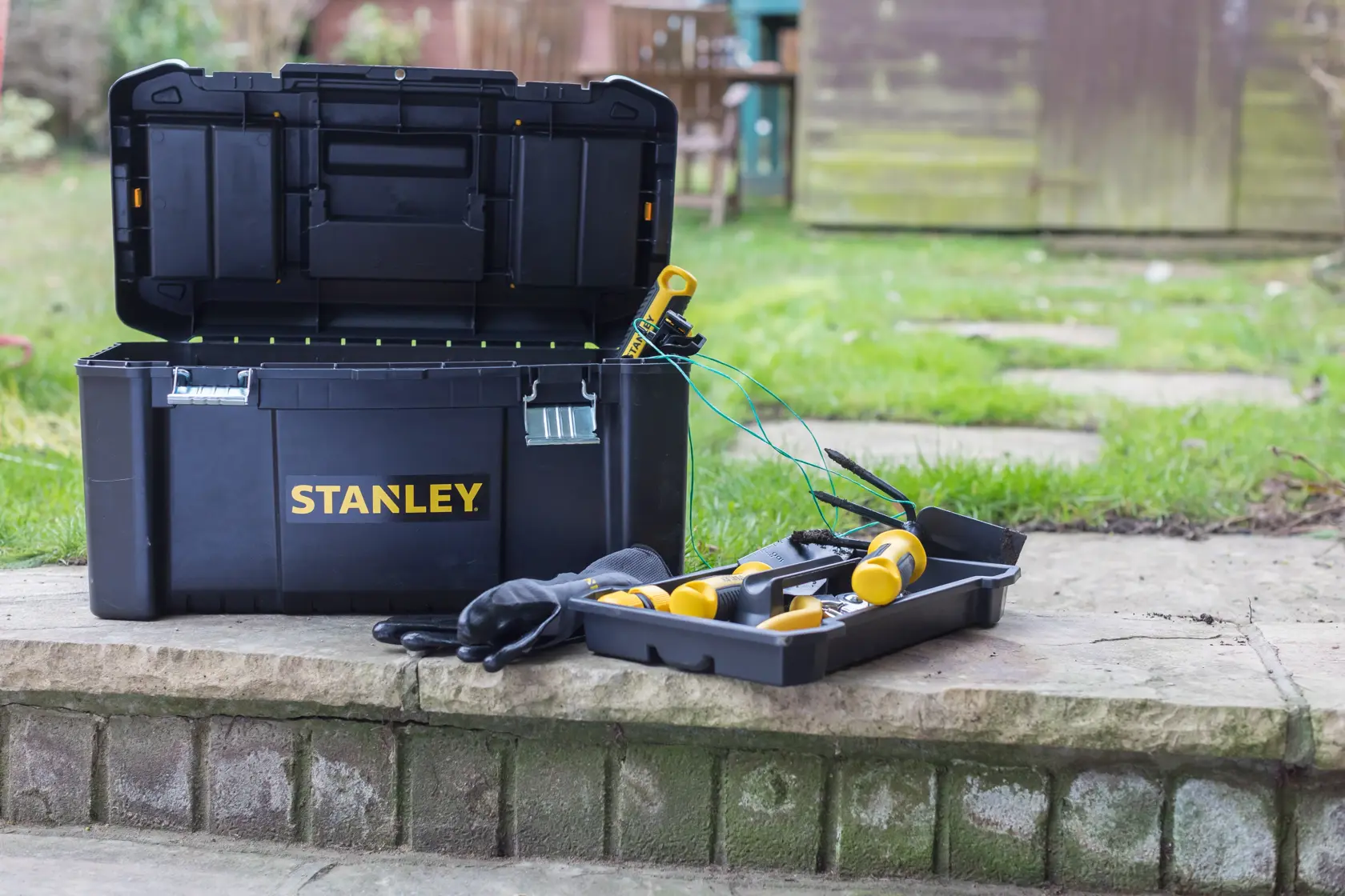 STANLEY STST1-75521, STST1-75521-KR Werkzeugkasten offen im Freien mit Fach, Werkzeugen, Handschuhen, Produktfoto.
