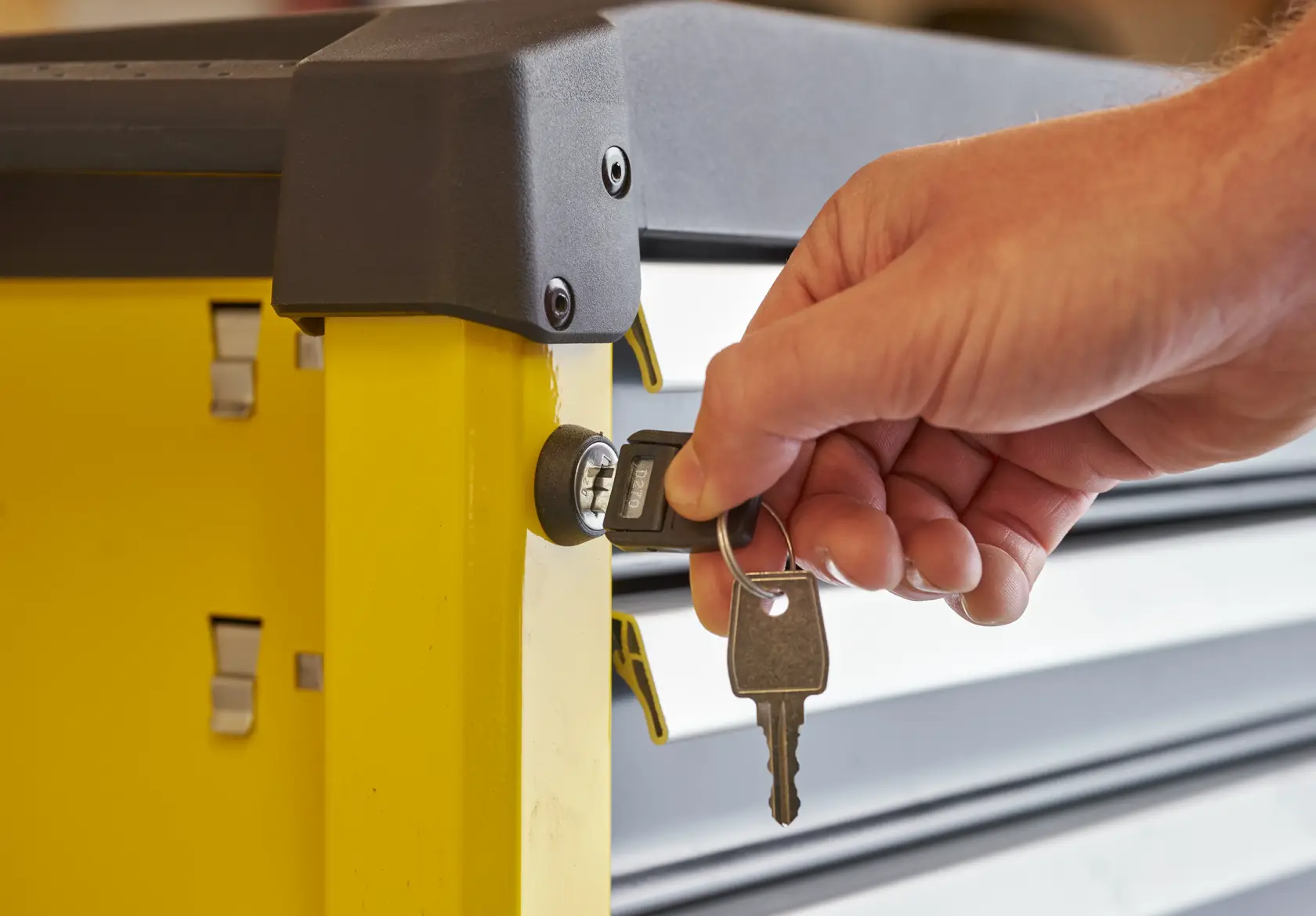 STANLEY STST74306-1 Werkzeugschrank Seitenansicht mit Hand, die einen Schlüssel ins Schloss steckt.